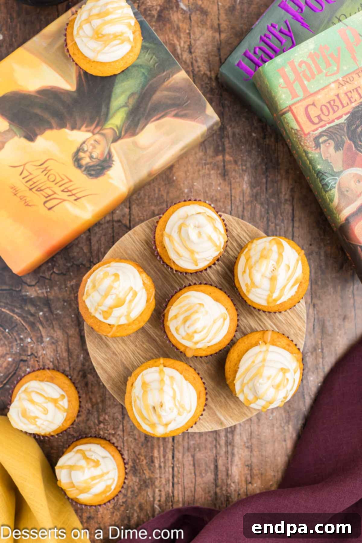 Baked Harry Potter cupcakes topped with swirls of butterscotch frosting and drizzled with extra butterscotch sauce, ready to serve.