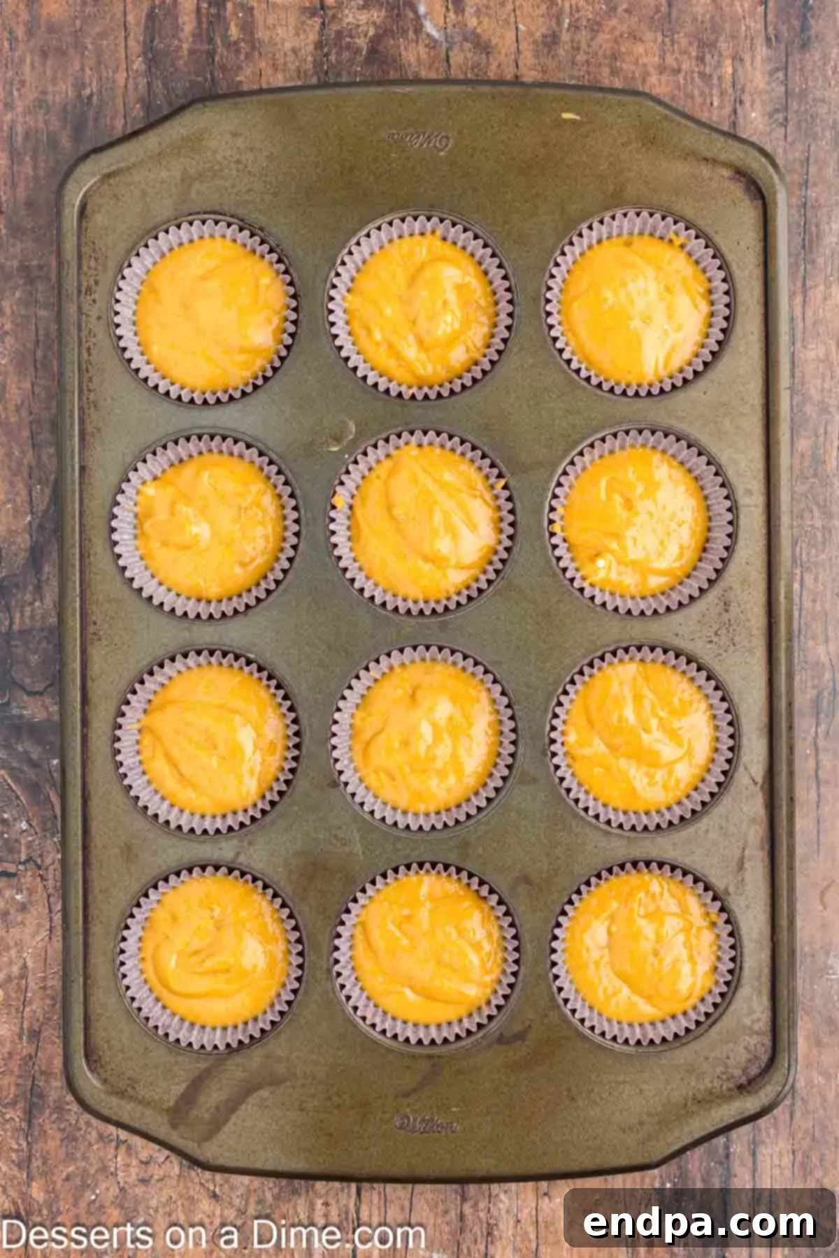 Cupcake batter carefully poured into lined muffin tins, ready for baking.