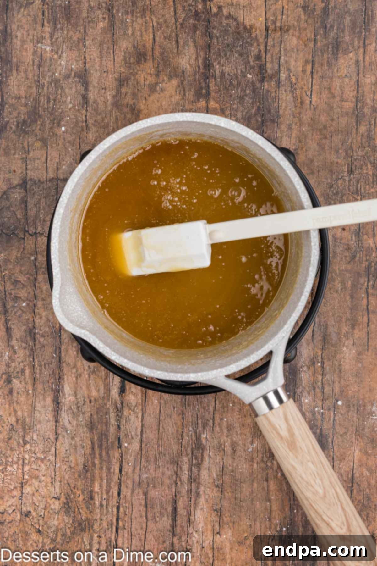Butterscotch sauce boiling gently in a saucepan, showing proper cooking consistency.