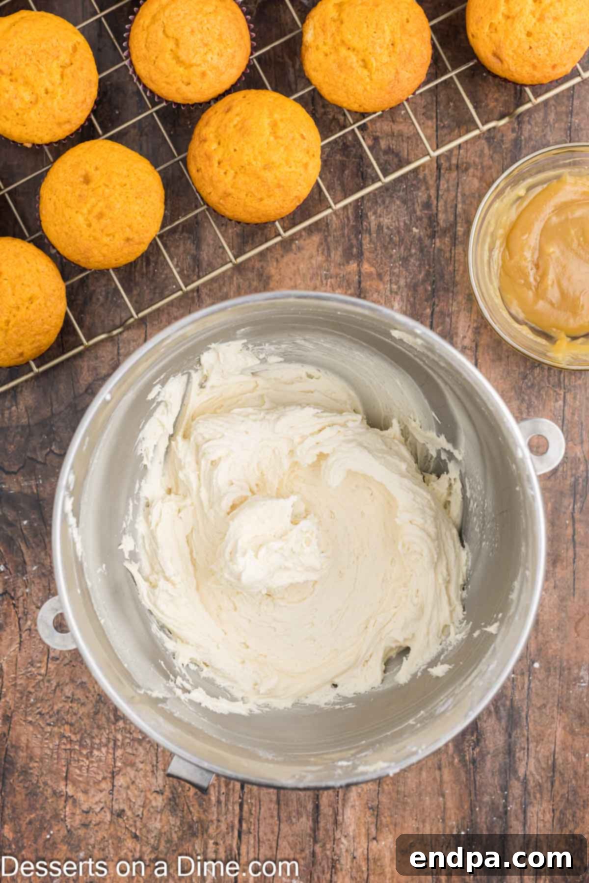 Powdered sugar being gradually added to the butterscotch frosting mixture in a stand mixer.