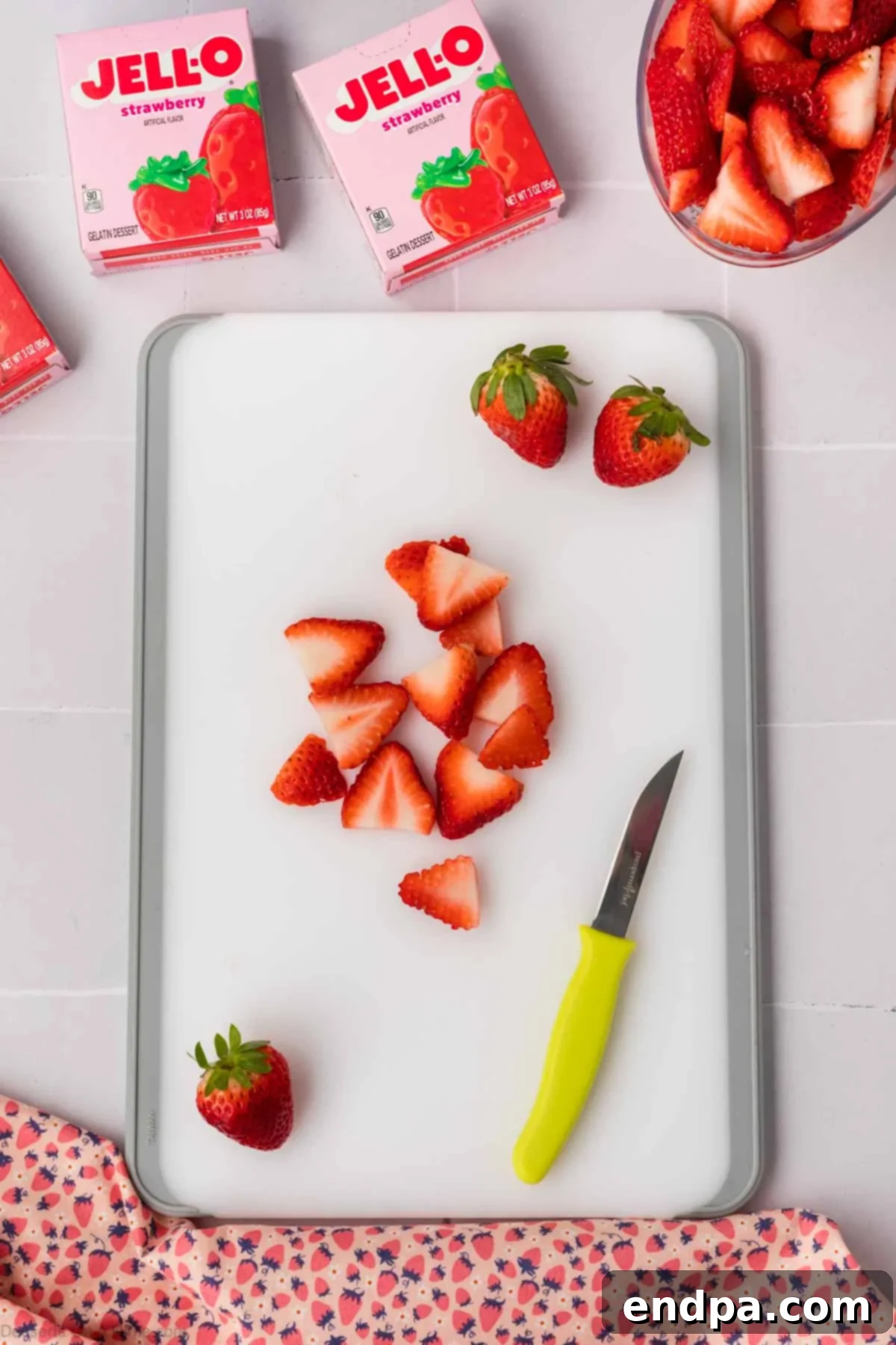 Fresh strawberry slices arranged on a cutting board, ready for use.