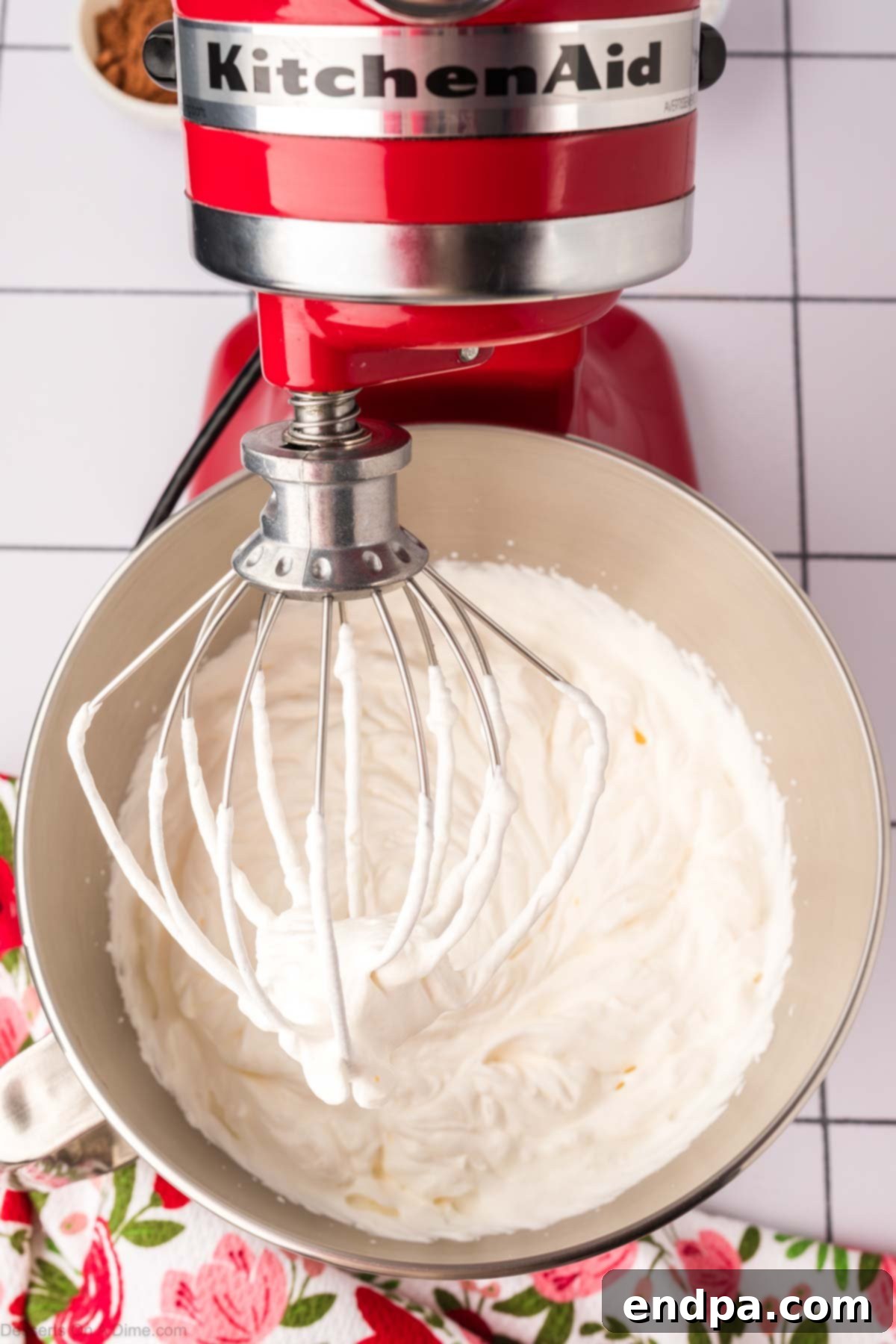 Light & Luscious Chocolate Frosting 5 Heavy cream being whipped until fluffy and forming soft peaks.