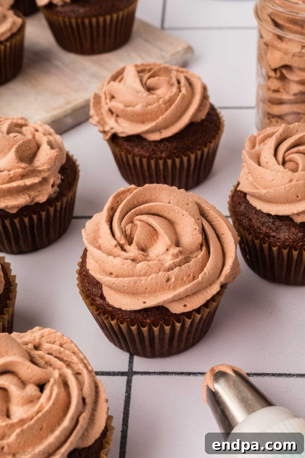 Light & Luscious Chocolate Frosting 8 Chocolate Whipped Cream Frosting elegantly piped onto cupcakes, ready to be served.
