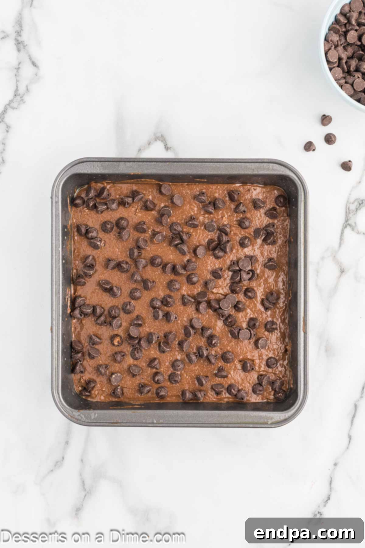 Decadent Cottage Cheese Swirl Brownies 7 Chocolate Chips sprinkled on top of brownie batter before baking.