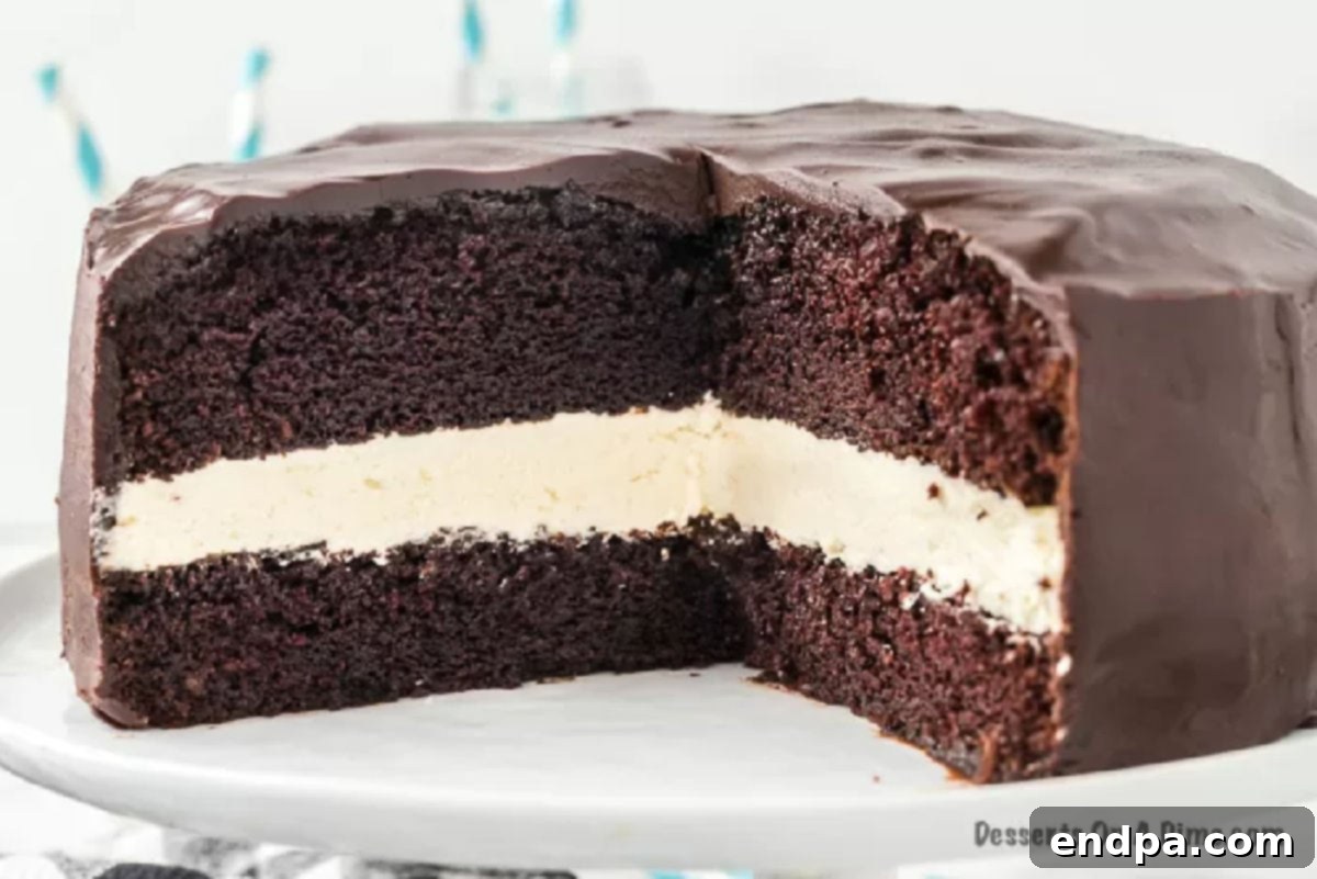 A beautifully sliced Ding Dong Cake on a platter, showcasing its distinct layers of chocolate cake, white cream filling, and chocolate glaze.