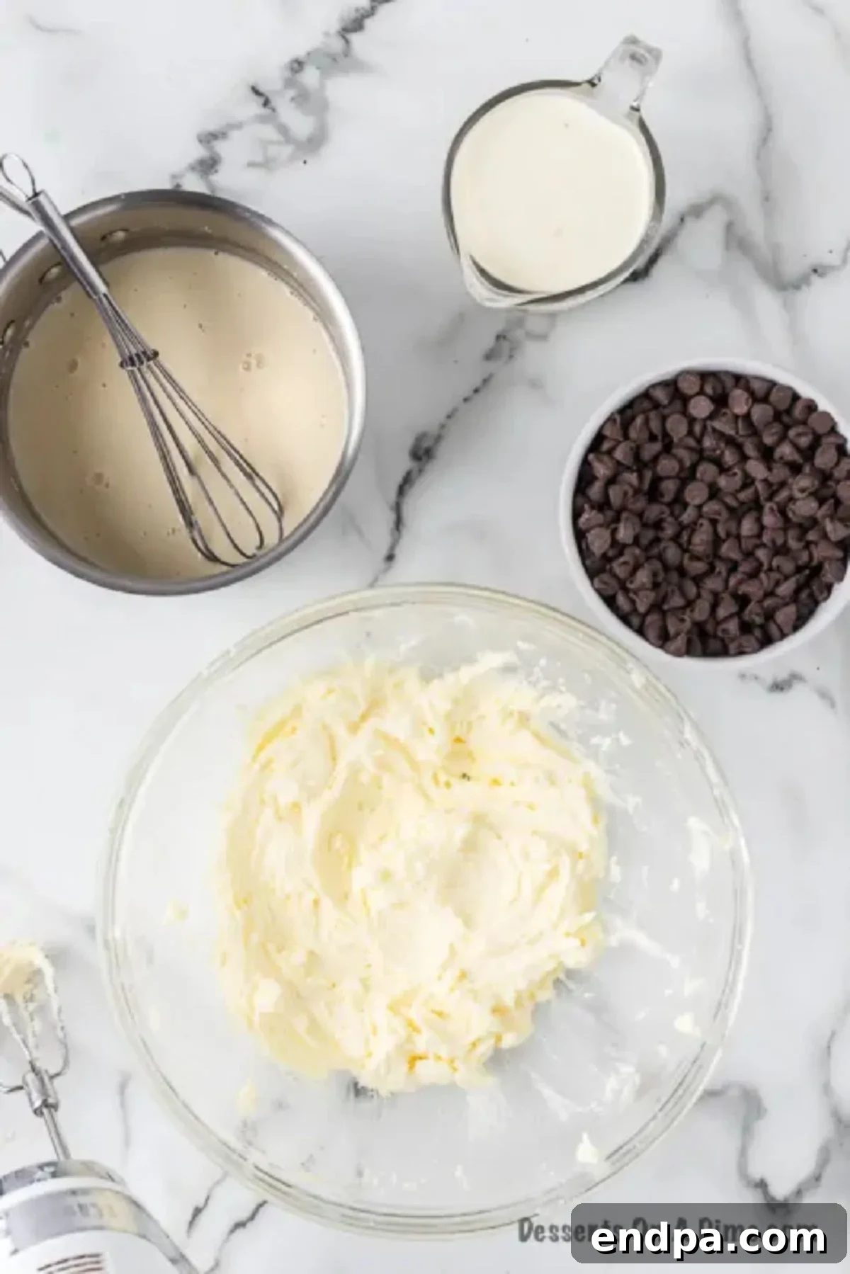 A large mixing bowl containing softened butter and sugar, being creamed together with an electric mixer for the cream filling.