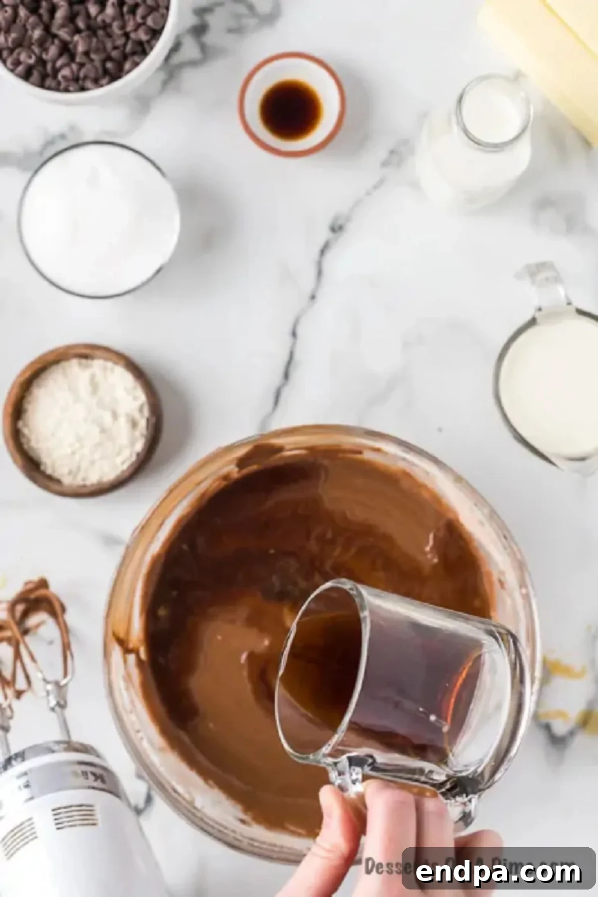 Cooled brewed coffee being slowly poured into the cake batter mixture.