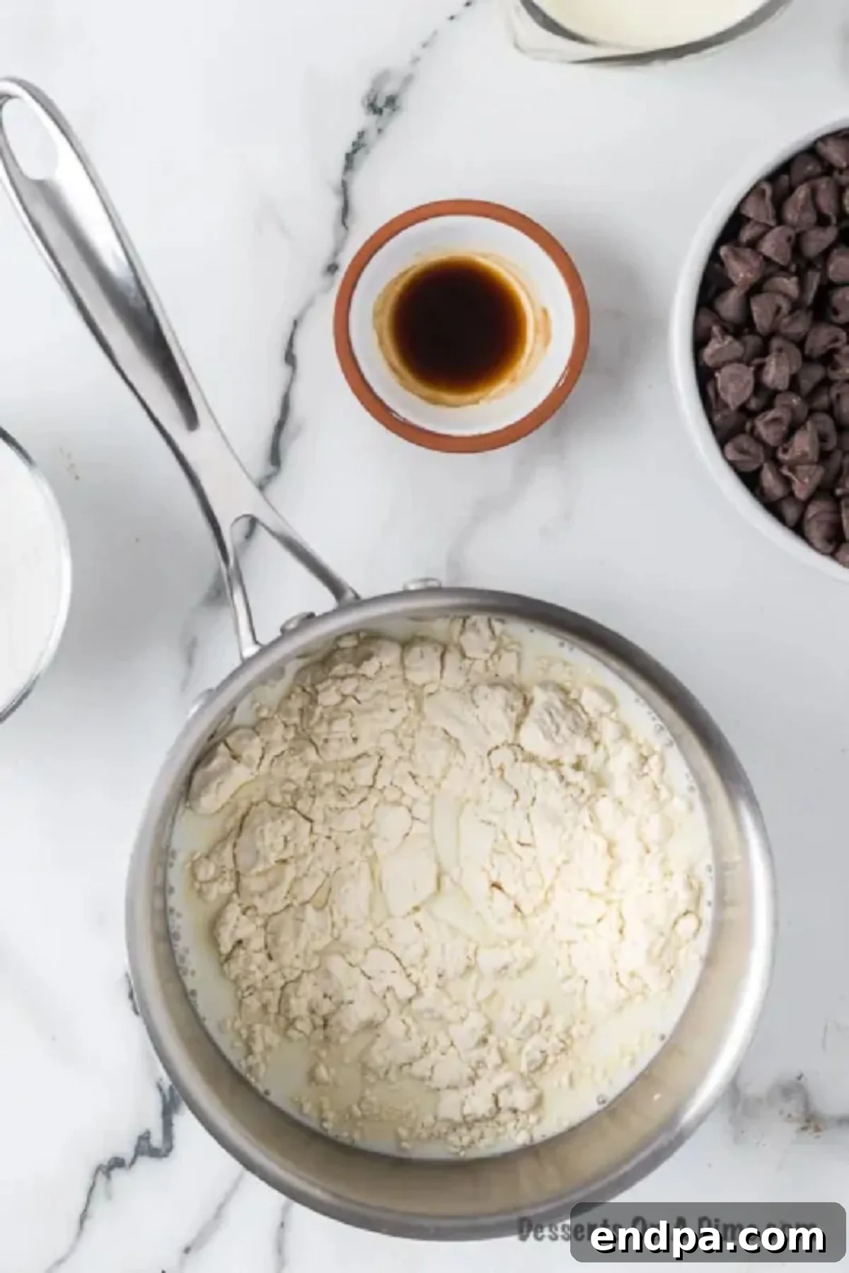 A small saucepan on the stove with milk and flour mixture, beginning to heat for the cream filling.