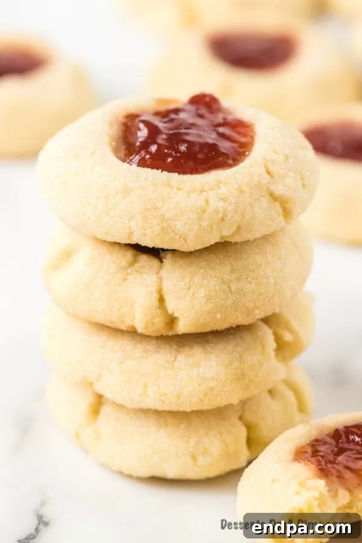 THUMBPRINT JAM COOKIES 2 Stacked Jam Thumbprint cookies with various jam fillings, showcasing their light, delicious texture.