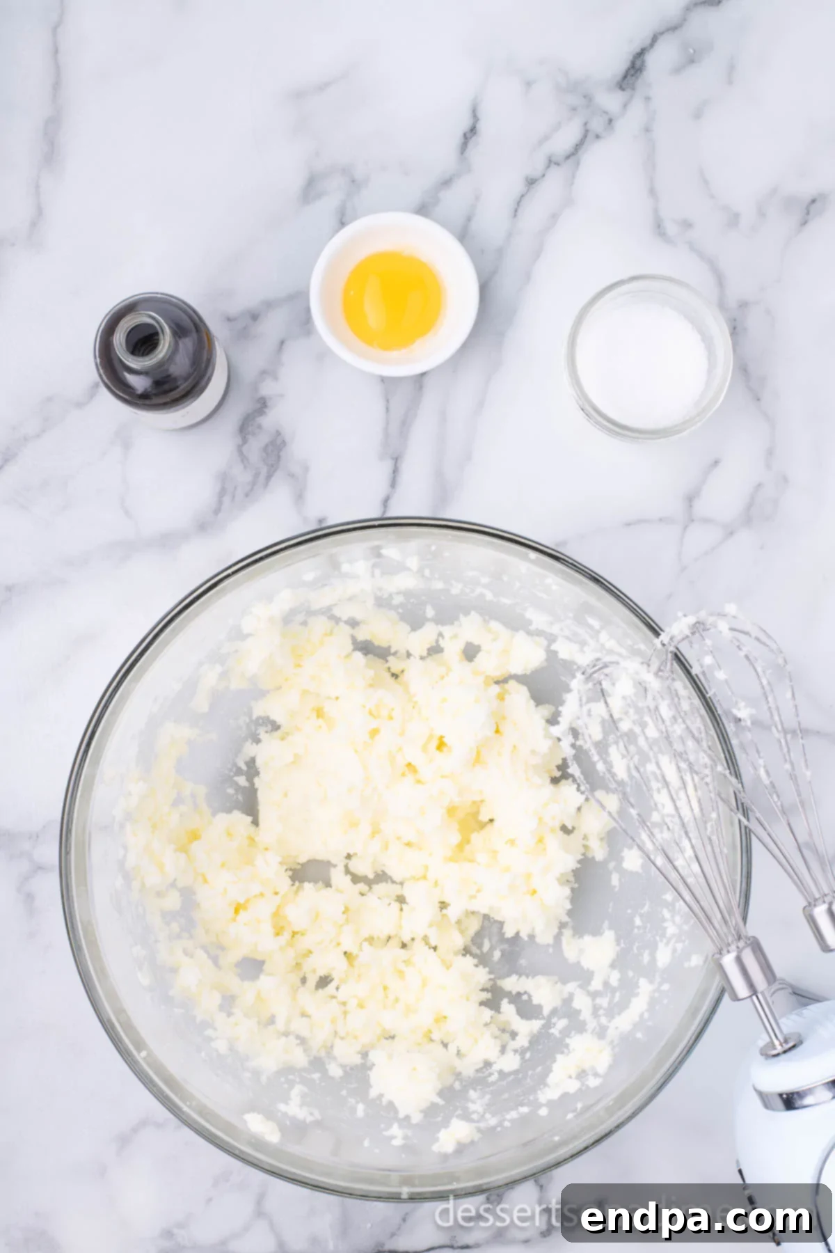 THUMBPRINT JAM COOKIES 5 Creamed butter and sugar mixture in a mixing bowl, showing a pale and fluffy consistency.