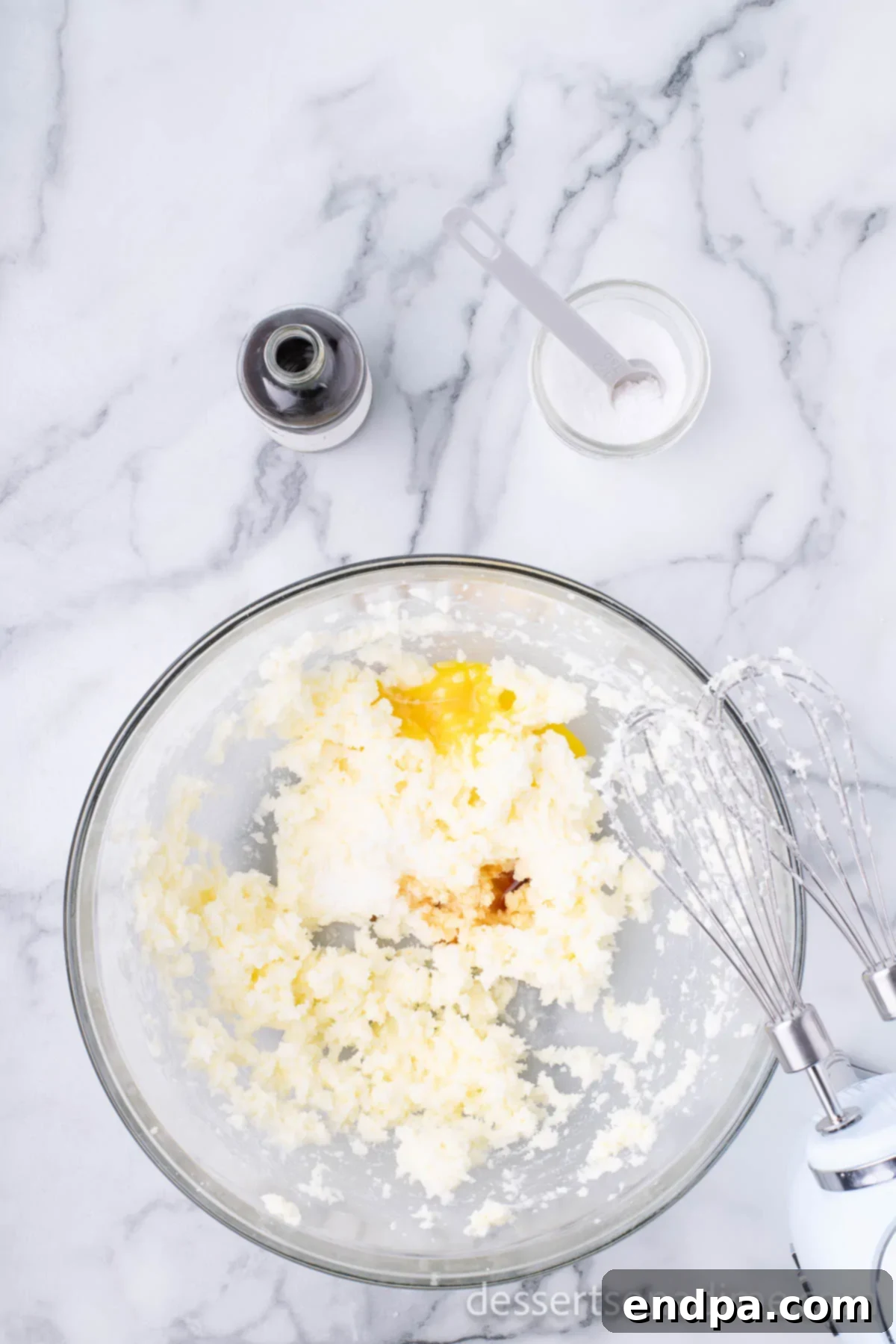 THUMBPRINT JAM COOKIES 6 Egg yolk and vanilla extract added to the butter and sugar mixture in a mixing bowl.