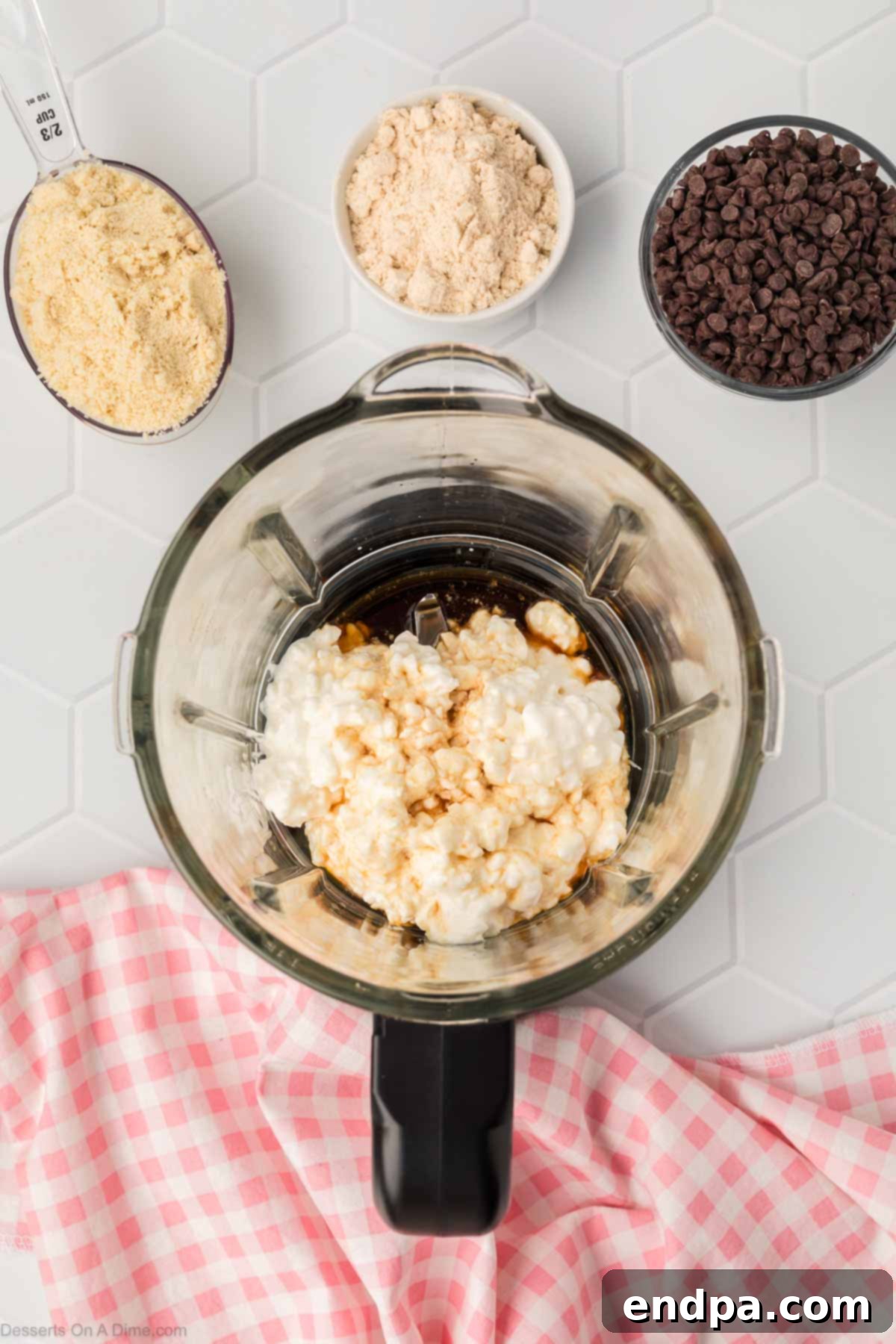 Full-fat cottage cheese, vanilla extract, and maple syrup are placed together in a blender cup, ready to be processed.