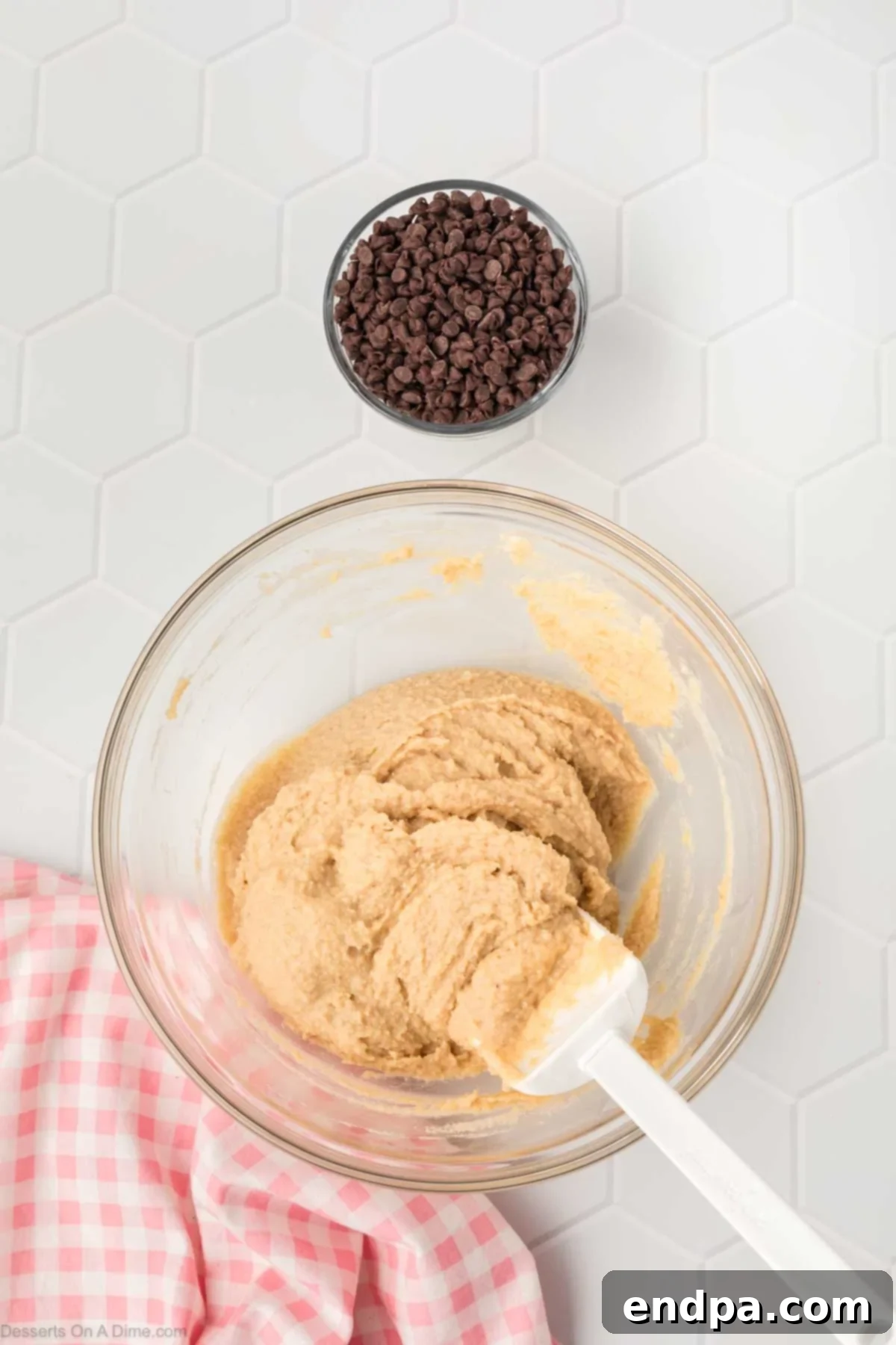 All the dry and wet ingredients have been mixed together in the bowl, forming a uniform, thick, and scoopable cookie dough batter.
