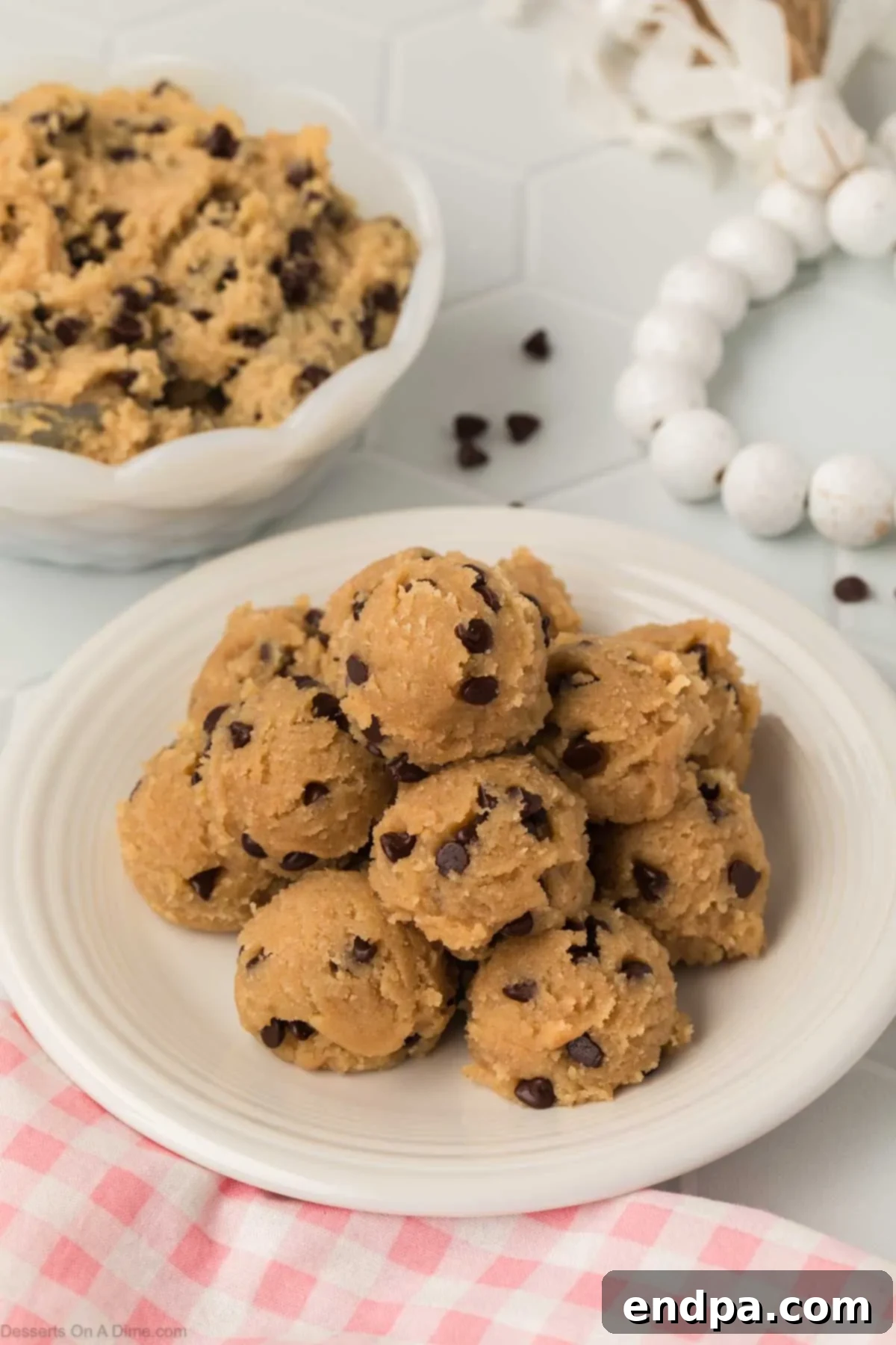 Several perfectly portioned Cottage Cheese Cookie Dough balls arranged neatly on a white plate, showcasing their smooth texture and chocolate chip speckles. Ideal for easy snacking or freezing.