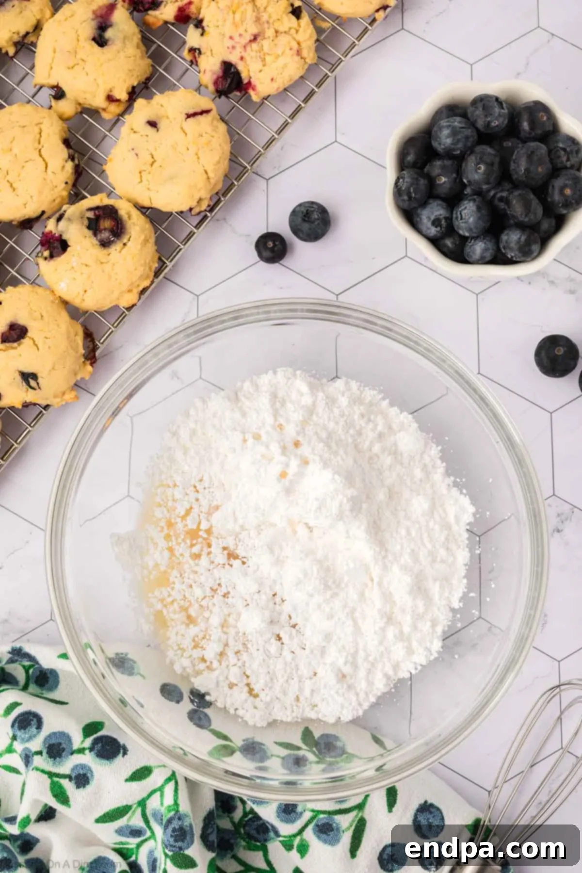 Ingredients for the lemon glaze, including powdered sugar, fresh lemon juice, and milk, combined in a bowl, ready to be whisked.