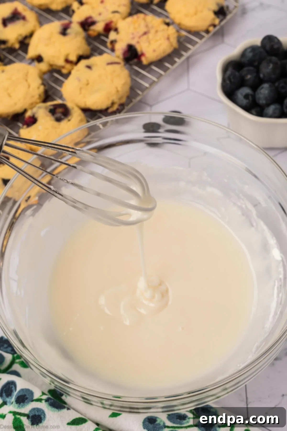The finished lemon glaze, smooth and ready for drizzling, in a bowl.