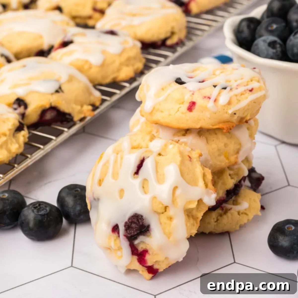 Close-up of a perfectly baked Lemon Blueberry Cookie with glaze, showing its soft interior and vibrant blueberries.