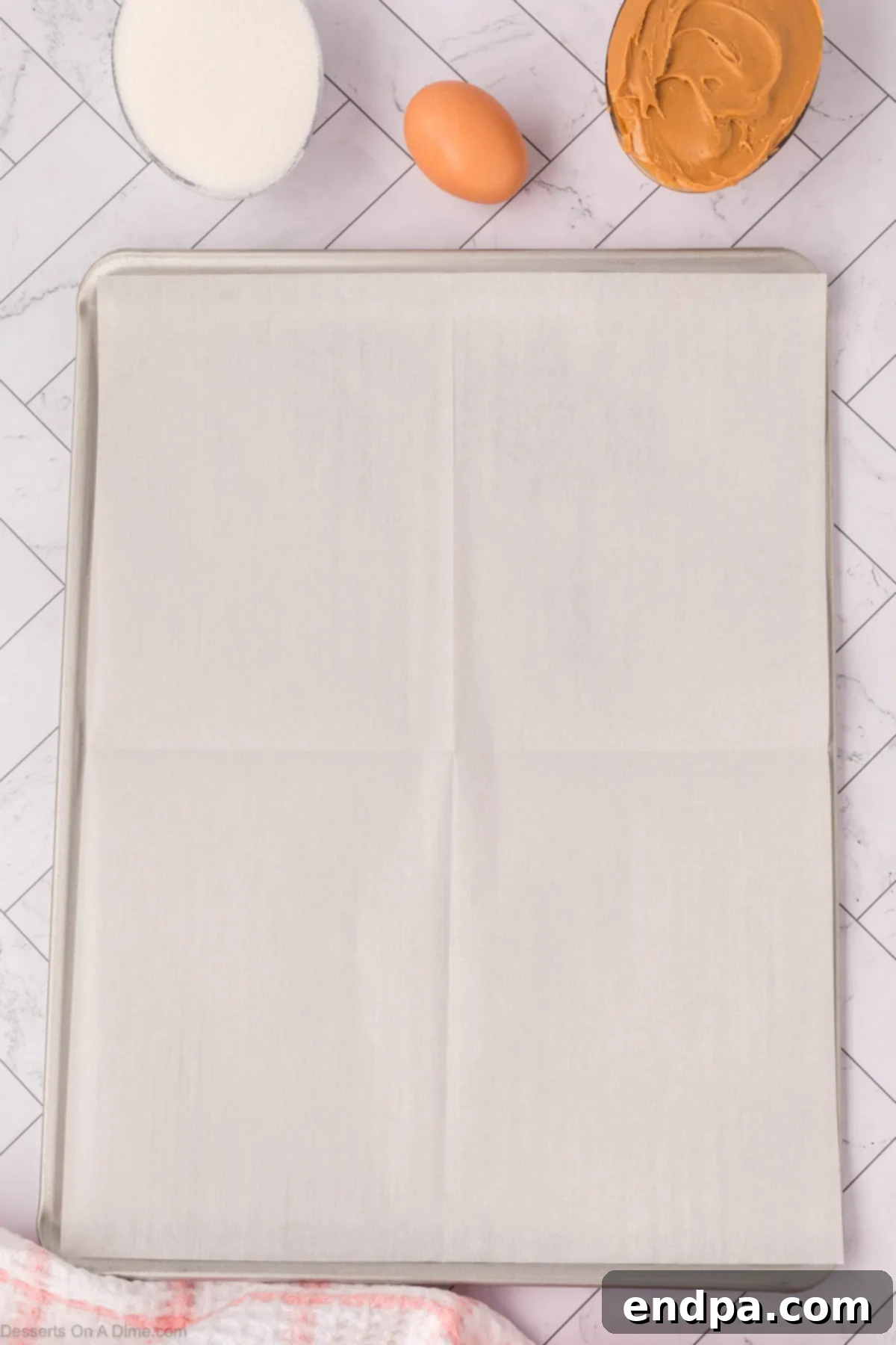Baking sheet lined with parchment paper, ready for cookie dough.