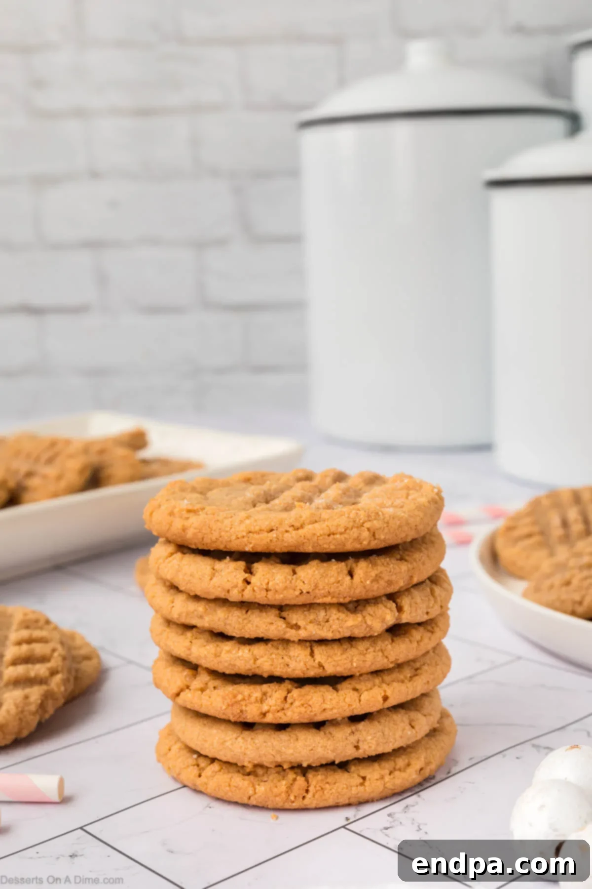 A stack of three 3-ingredient peanut butter cookies on a serving platter, showing their soft texture.