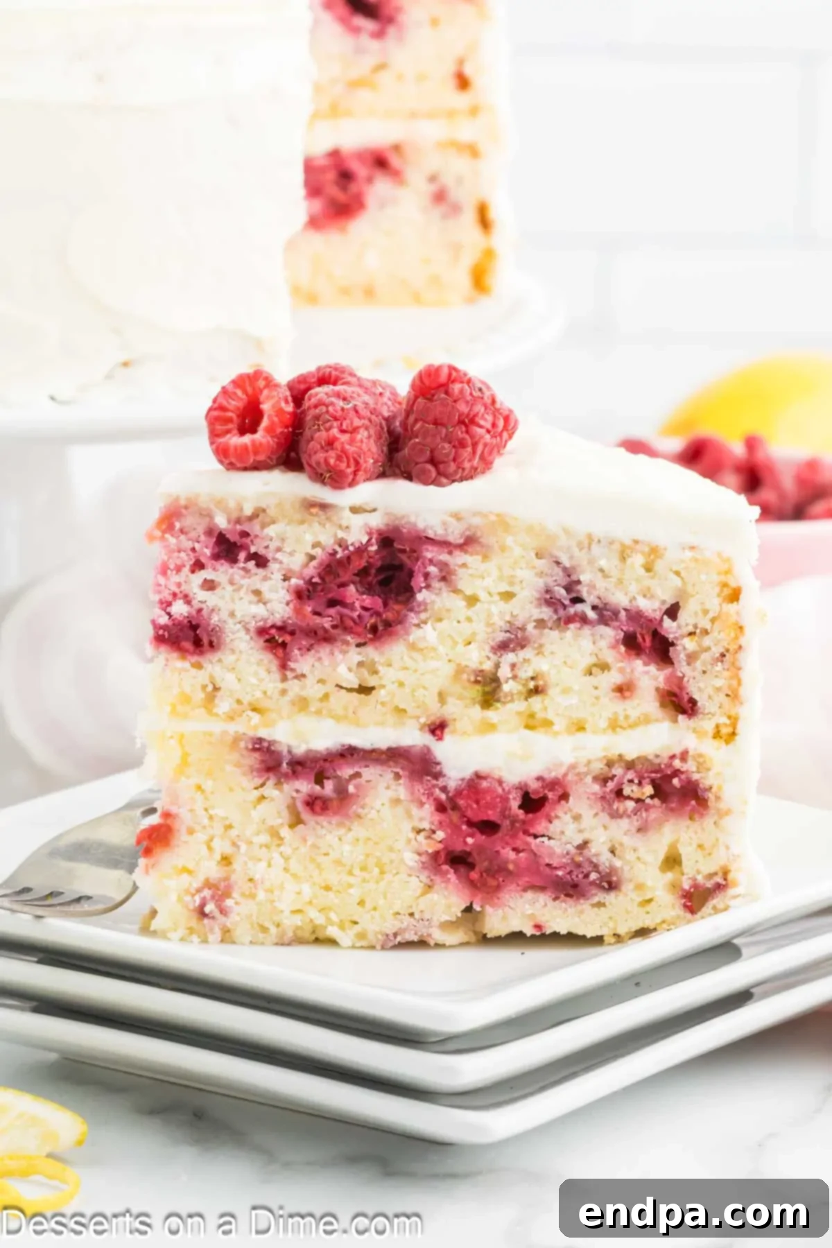 Lemon Berry Bliss 15 A slice of lemon raspberry cake on a plate, ready to be enjoyed.