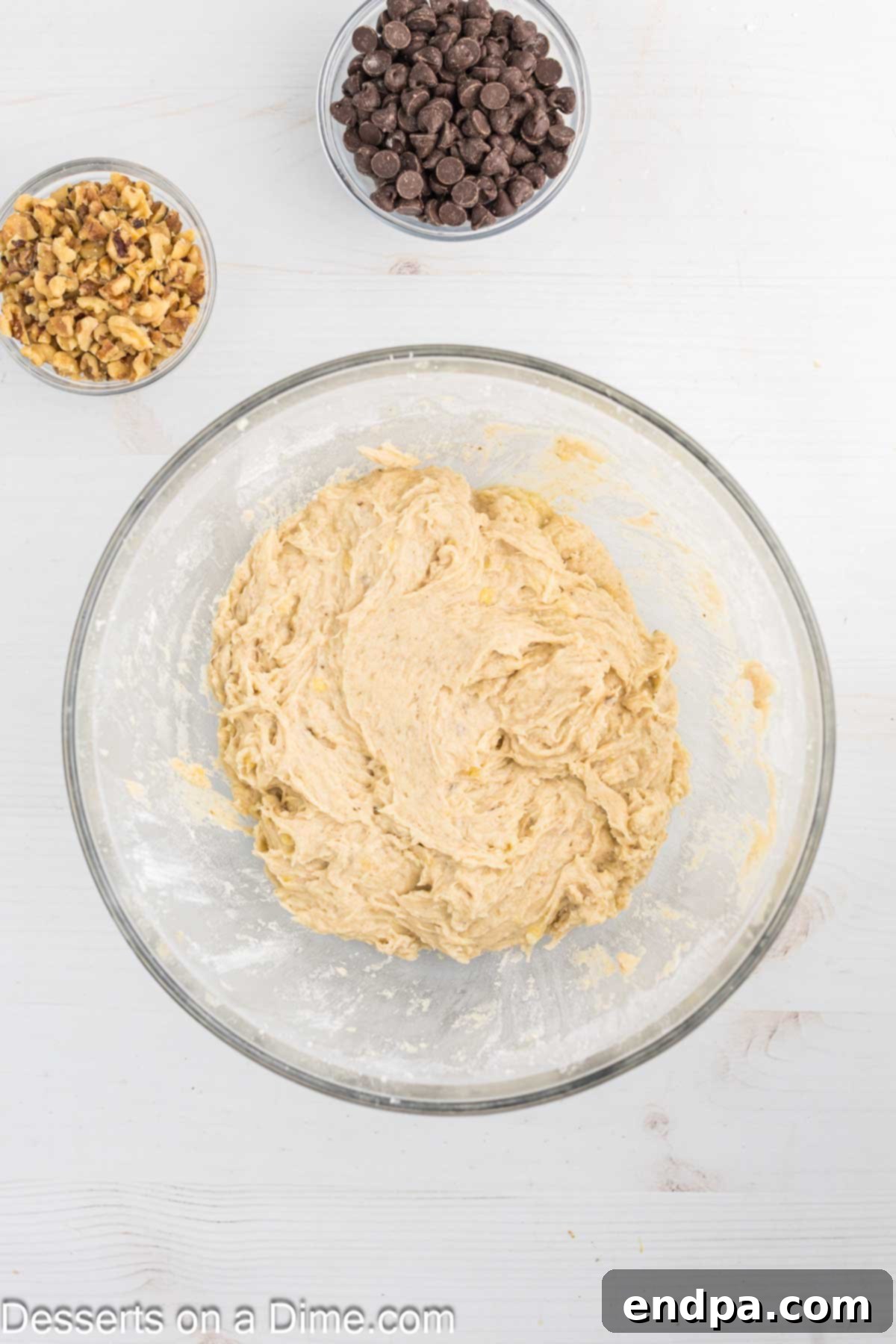 The combined dry ingredients (flour, baking soda, salt, cinnamon) being gently folded into the wet banana mixture.