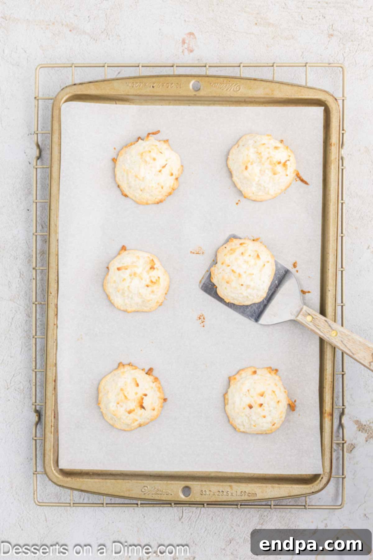Golden-brown Coconut Macaroons freshly baked on a baking sheet, ready to be cooled.