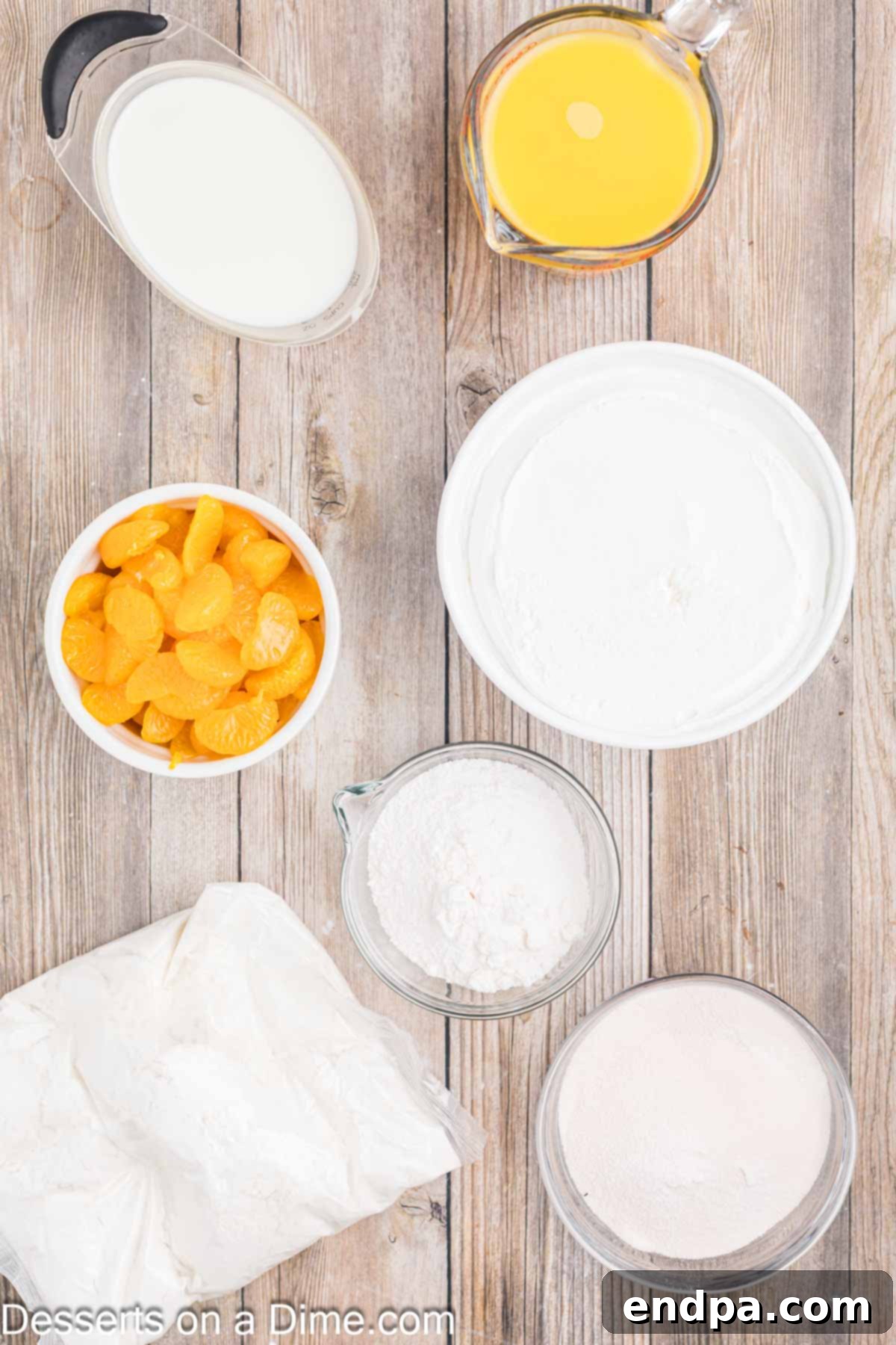 Velvet Orange Dream Cake 3 Key ingredients laid out for Orange Creamsicle Cake: a box of white cake mix, bottle of orange juice, orange gelatin, vanilla instant pudding mix, milk, whipped topping, and canned mandarin oranges for garnish.