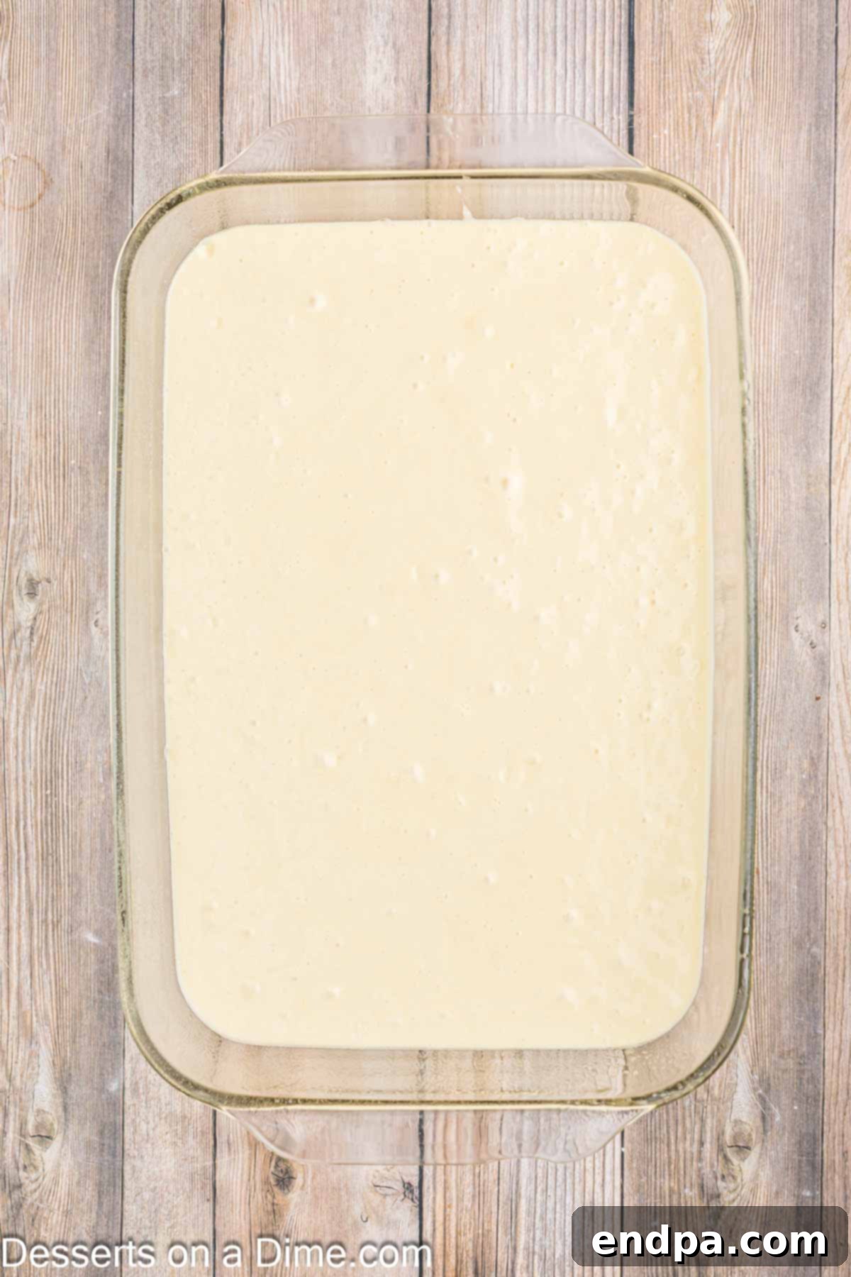 Velvet Orange Dream Cake 5 Smooth orange-infused cake batter poured evenly into a 9x13 inch baking pan, ready for the oven.