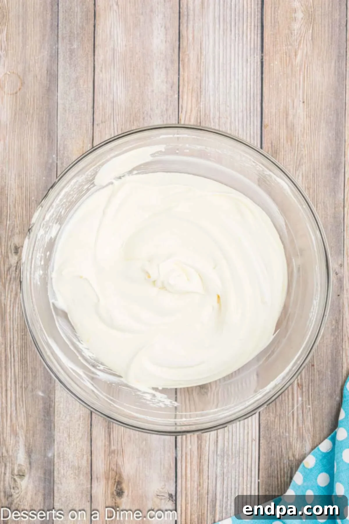 Velvet Orange Dream Cake 9 Creamy, fluffy orange creamsicle frosting, a blend of vanilla pudding and whipped topping, combined in a large mixing bowl.