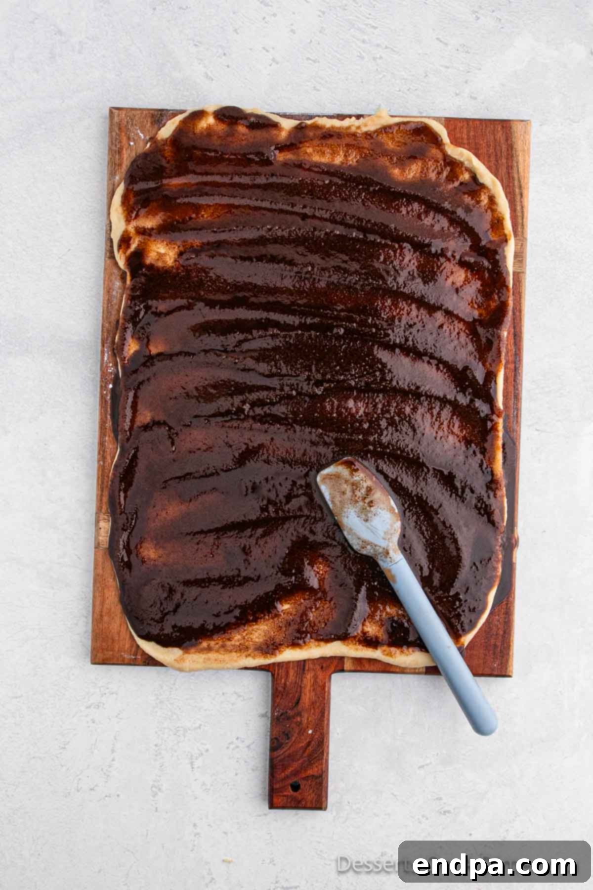 The cinnamon sugar filling spread evenly over the surface of the rolled-out dough rectangle.