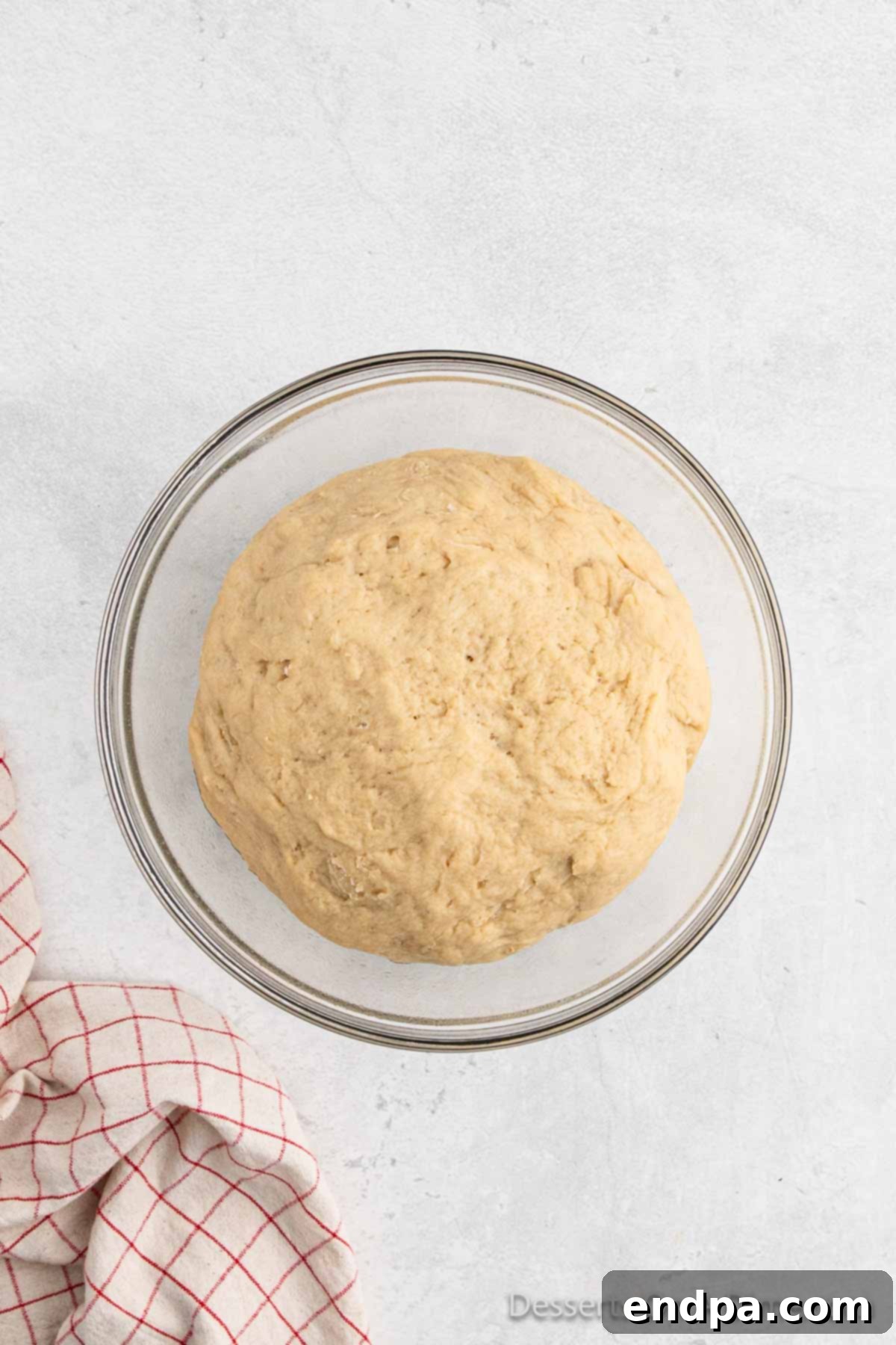 The dough in the bowl, visibly risen and doubled in size after the initial proofing period.