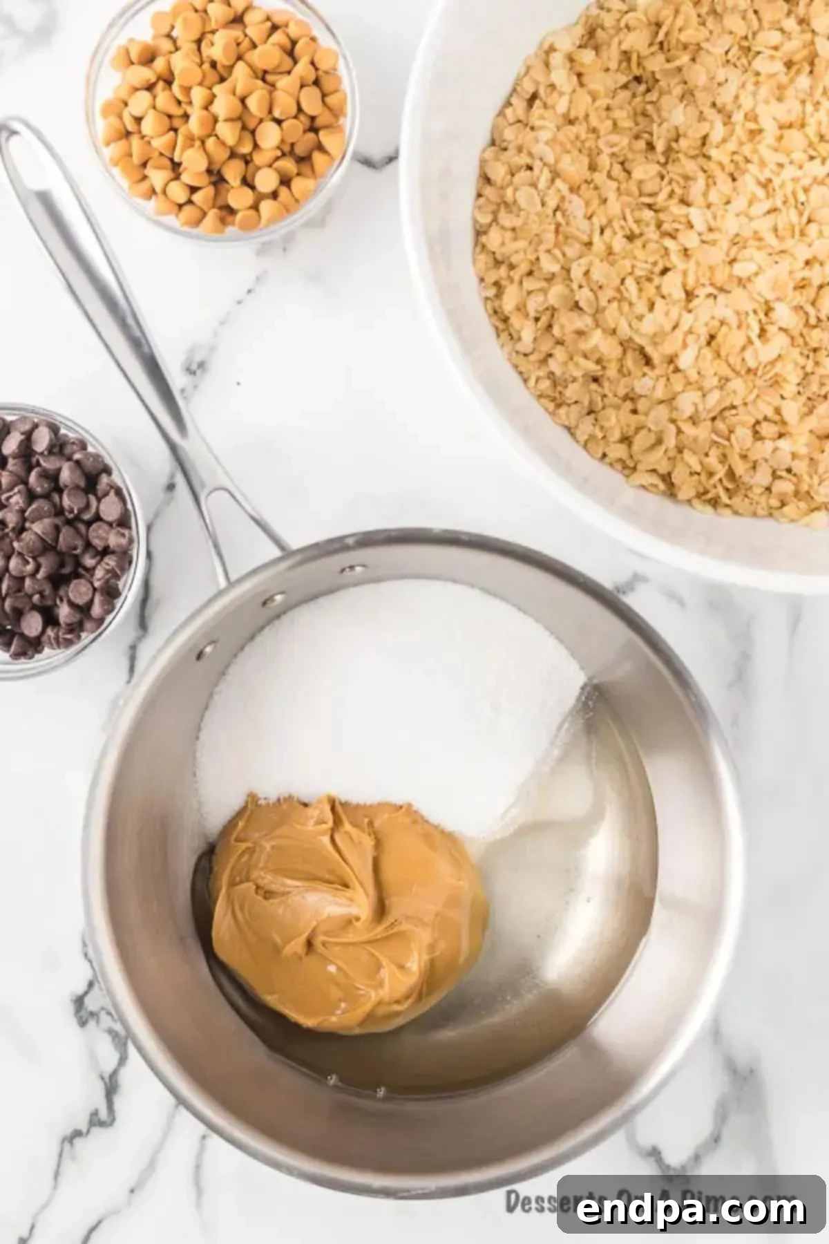 A medium saucepan on a stovetop with creamy peanut butter, granulated sugar, and light corn syrup, showing the ingredients beginning to melt and combine.