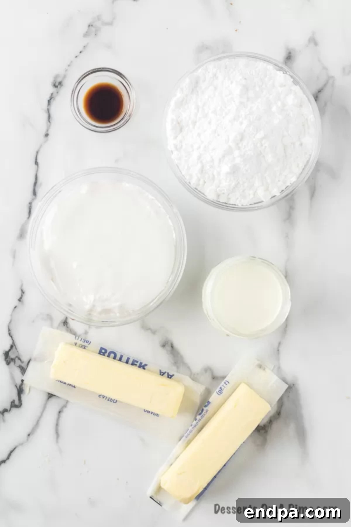 Homemade Marshmallow Frosting Ingredients: butter, marshmallow fluff, powdered sugar, vanilla extract, milk laid out on a clean surface.