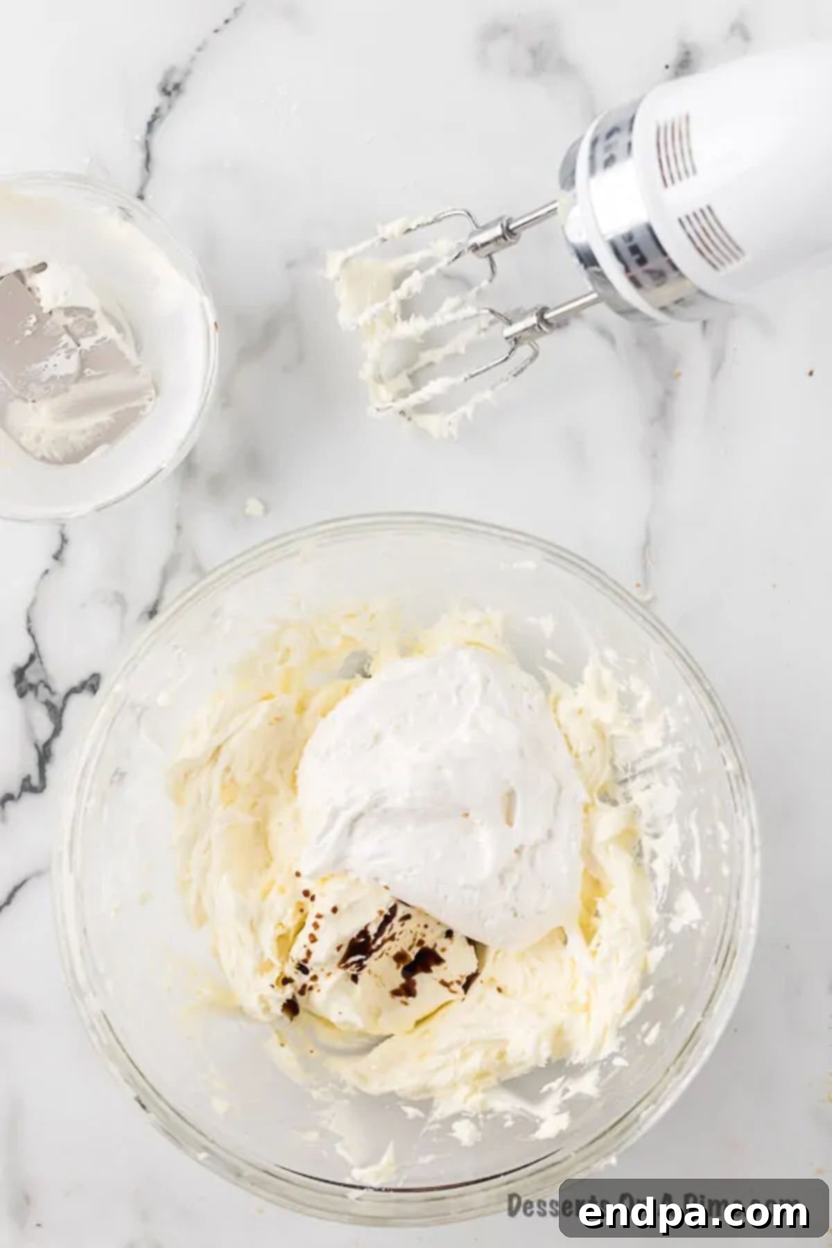 Adding marshmallow fluff and vanilla extract to the creamed butter and sugar mixture.