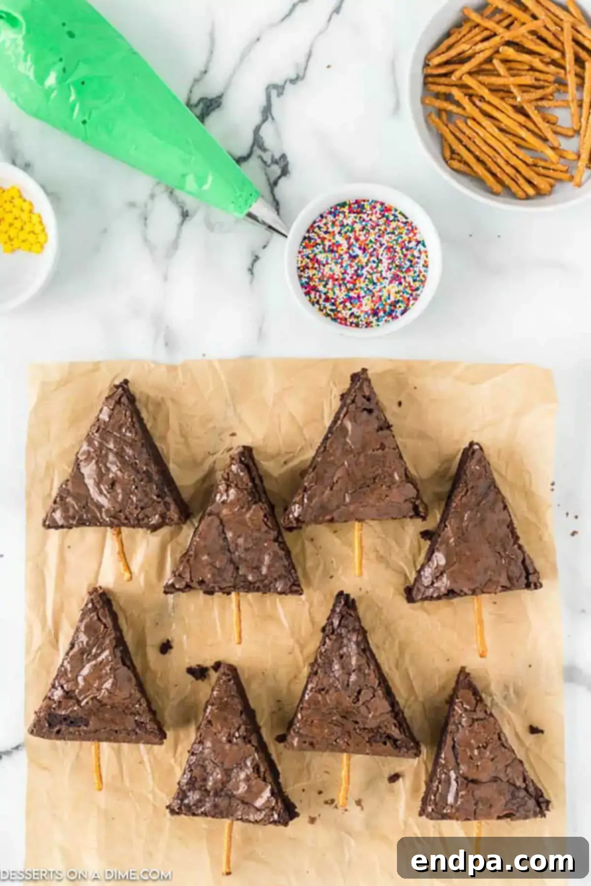 Fudgy brownies meticulously cut into perfect triangle shapes on a wooden board, ready for decorating.