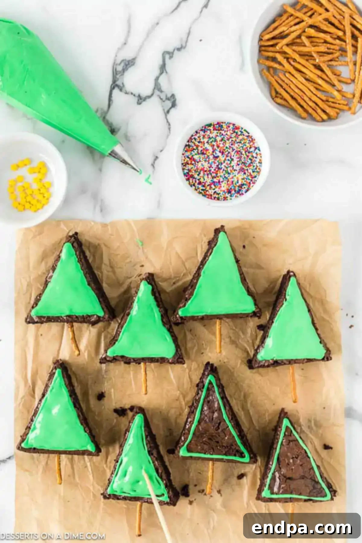 A brownie triangle with green icing smoothly applied, creating the base for the Christmas tree decoration.