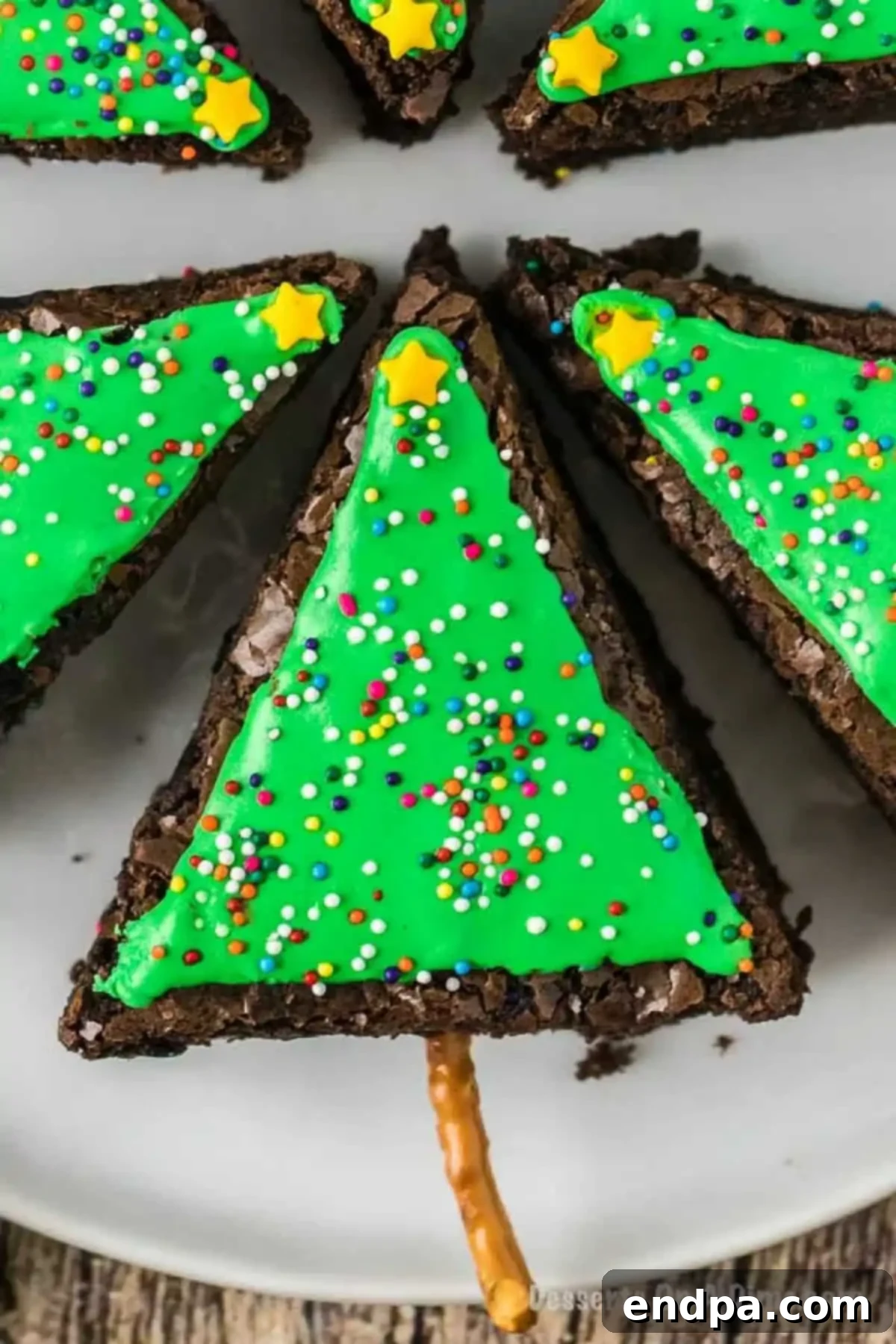 Decorated Christmas tree brownies adorned with colorful sprinkles and a star on top, showcasing the festive final product.