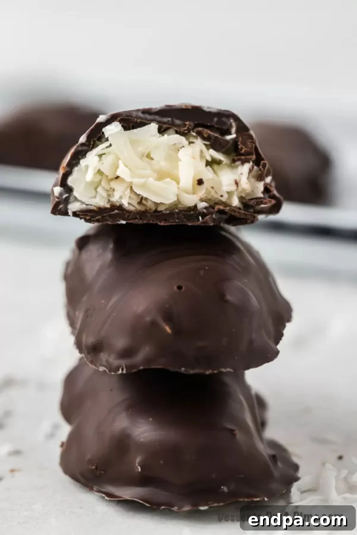 Decadent Homemade Mounds Bars 2 Stacked Homemade Mounds Bars with dark chocolate coating and white coconut filling visible.