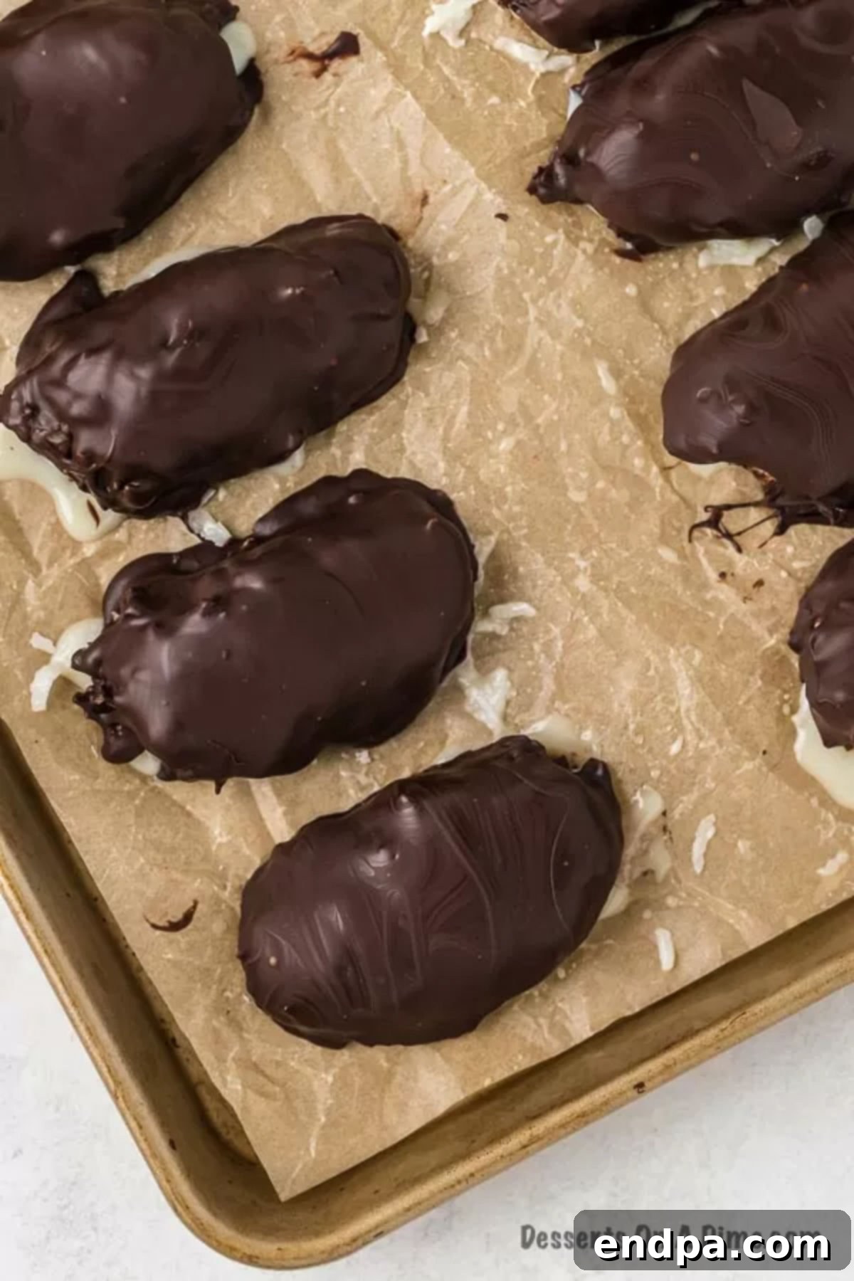 Decadent Homemade Mounds Bars 11 All chocolate-dipped mounds on a baking sheet, waiting for the chocolate to fully set.