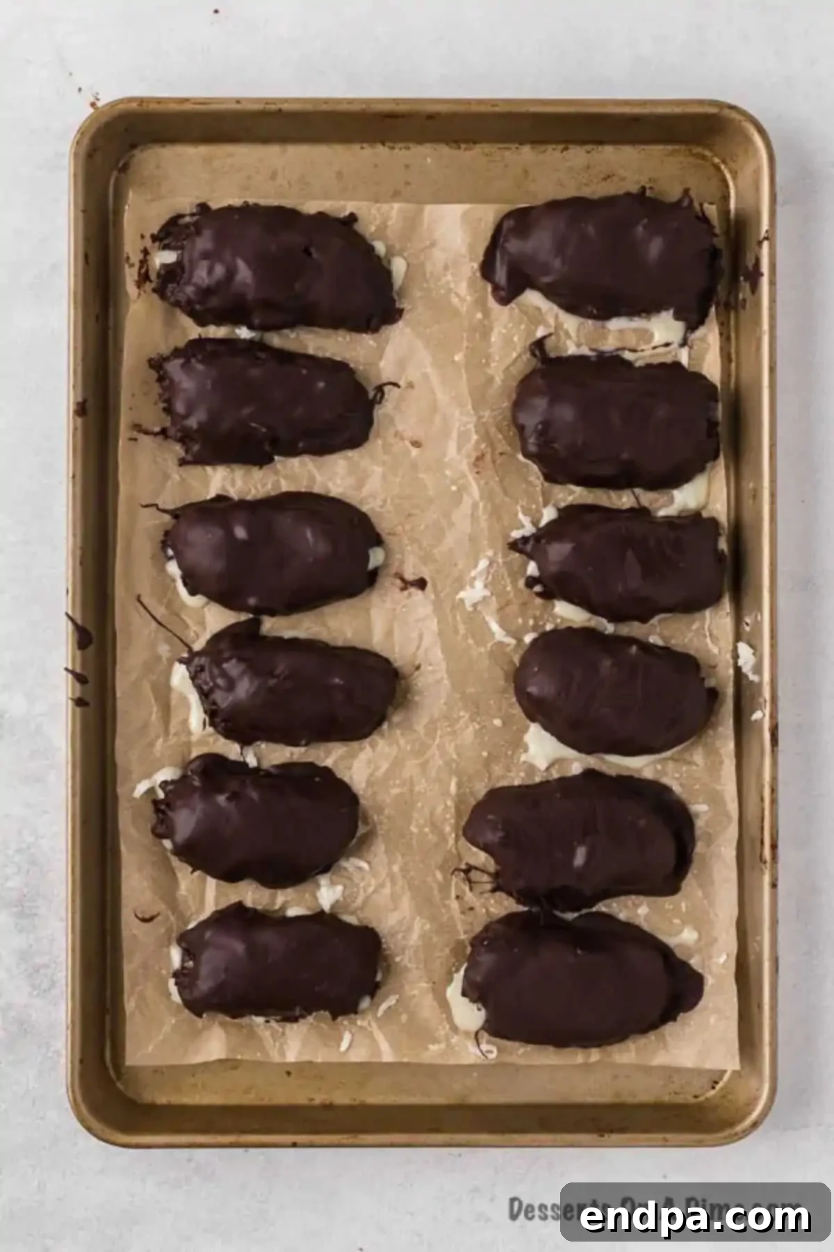 Decadent Homemade Mounds Bars 10 Chocolate-dipped mounds placed back on a parchment-lined baking sheet.