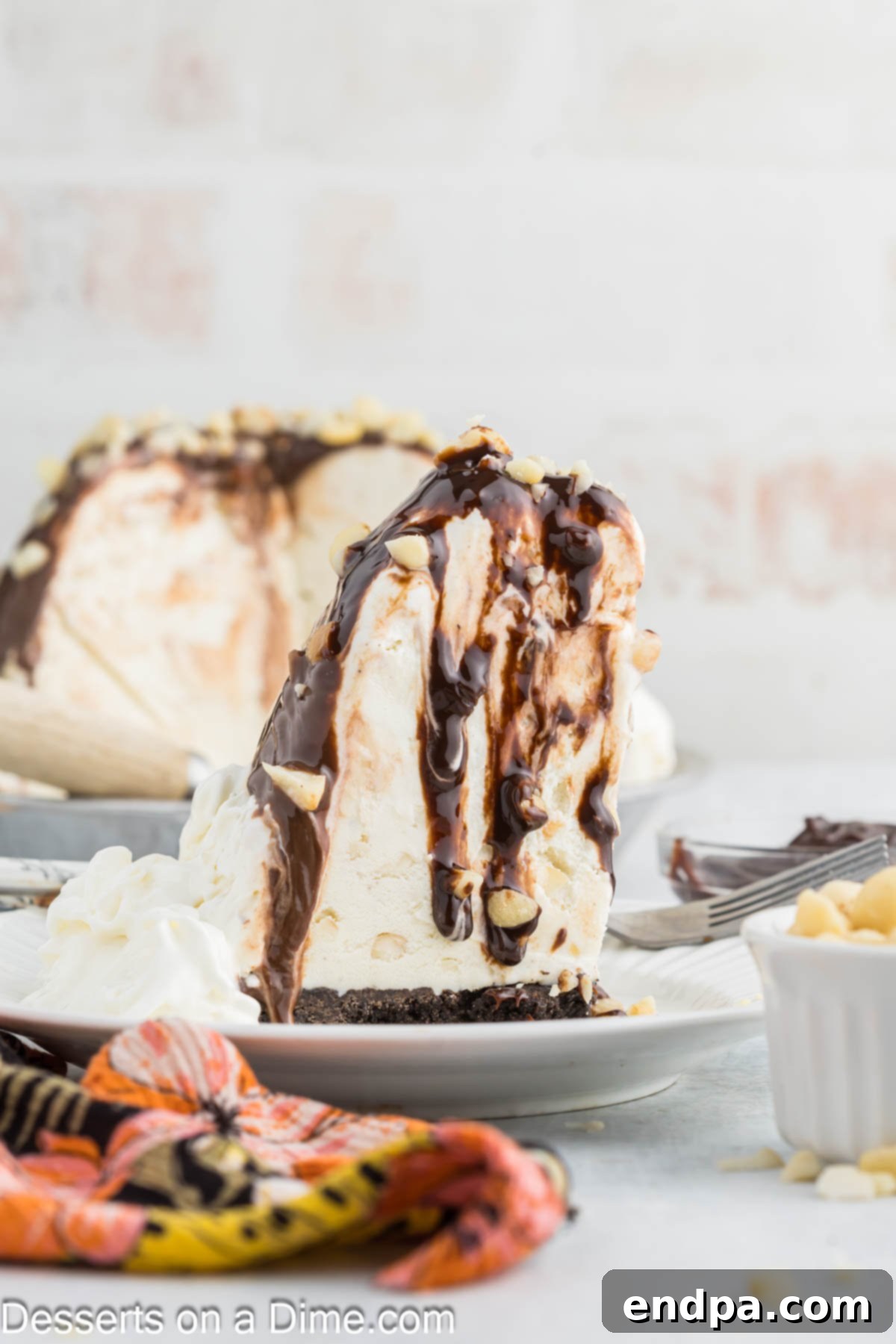 Hula Pie 12 A delicious slice of Hula Pie garnished with whipped cream and macadamia nuts, showcasing its layers.