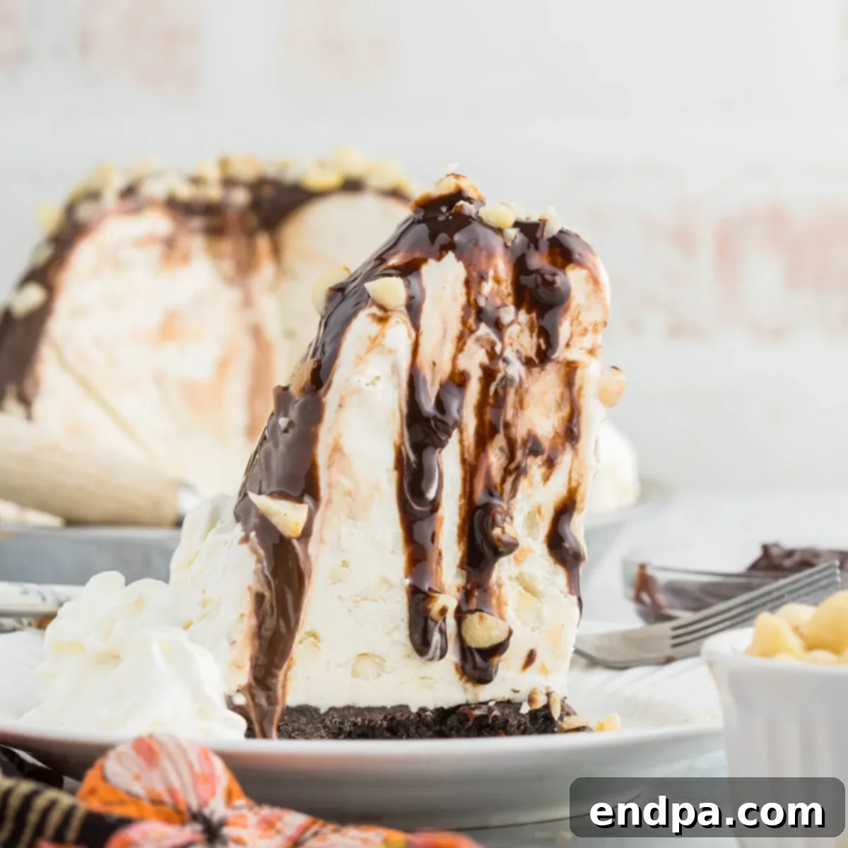 Hula Pie 13 A delectable slice of Hula Pie, featuring a rich chocolate crust, creamy macadamia nut ice cream, and fudge topping.