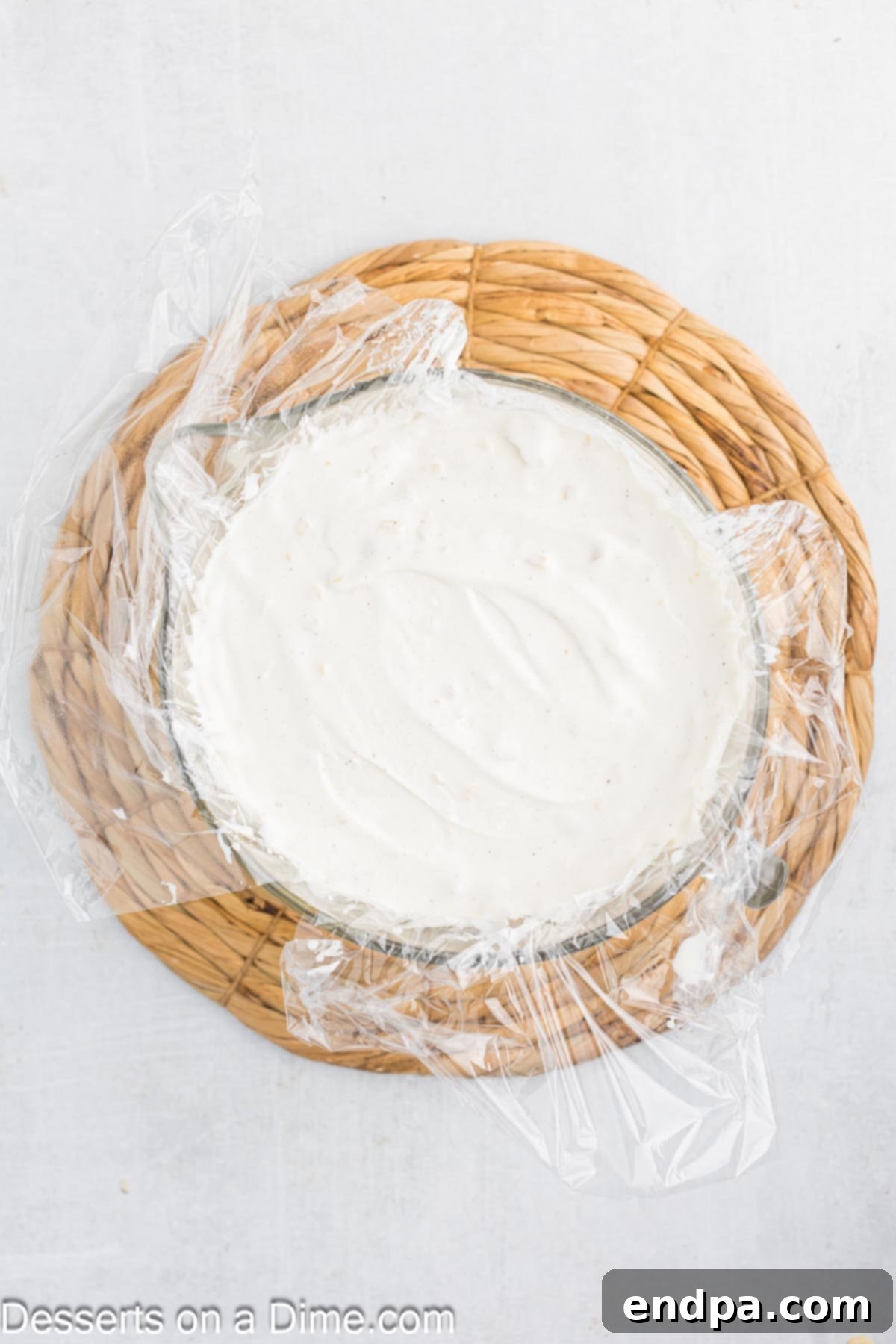 Hula Pie 7 A dome of macadamia nut ice cream covered in plastic wrap, ready for freezing.