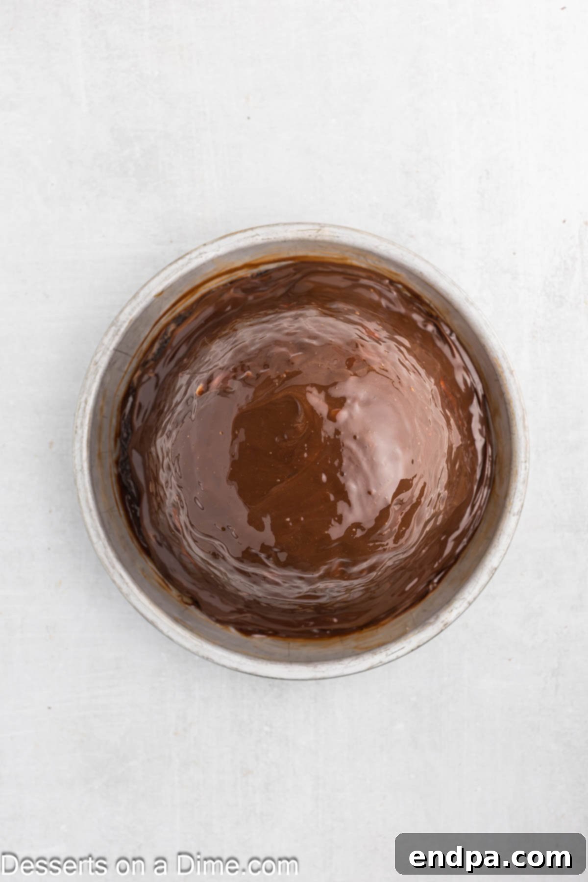 Hula Pie 9 Hot fudge sauce being spread over the dome of macadamia nut ice cream.