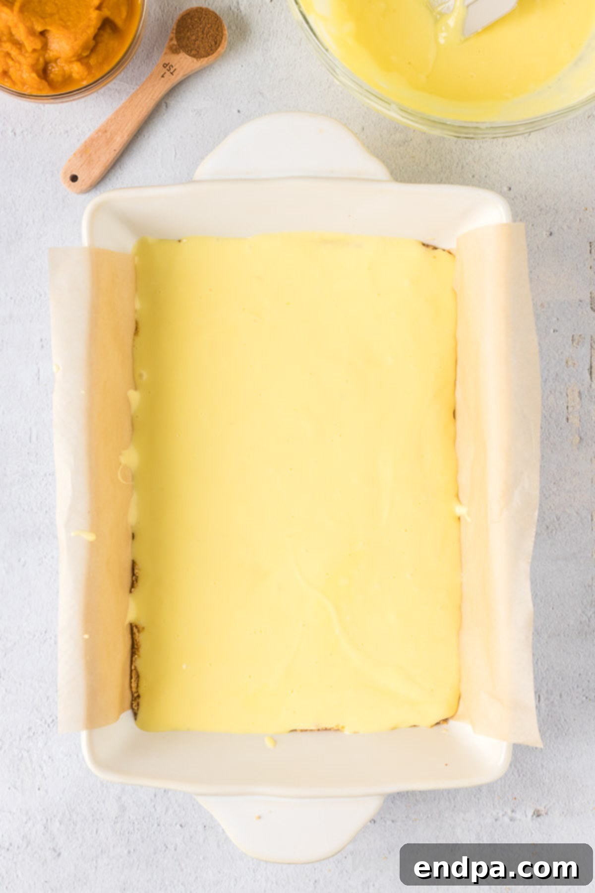 Spiced Pumpkin Cheesecake Bars 8 Half of the cream cheese mixture spread on top of the crust in the baking dish.
