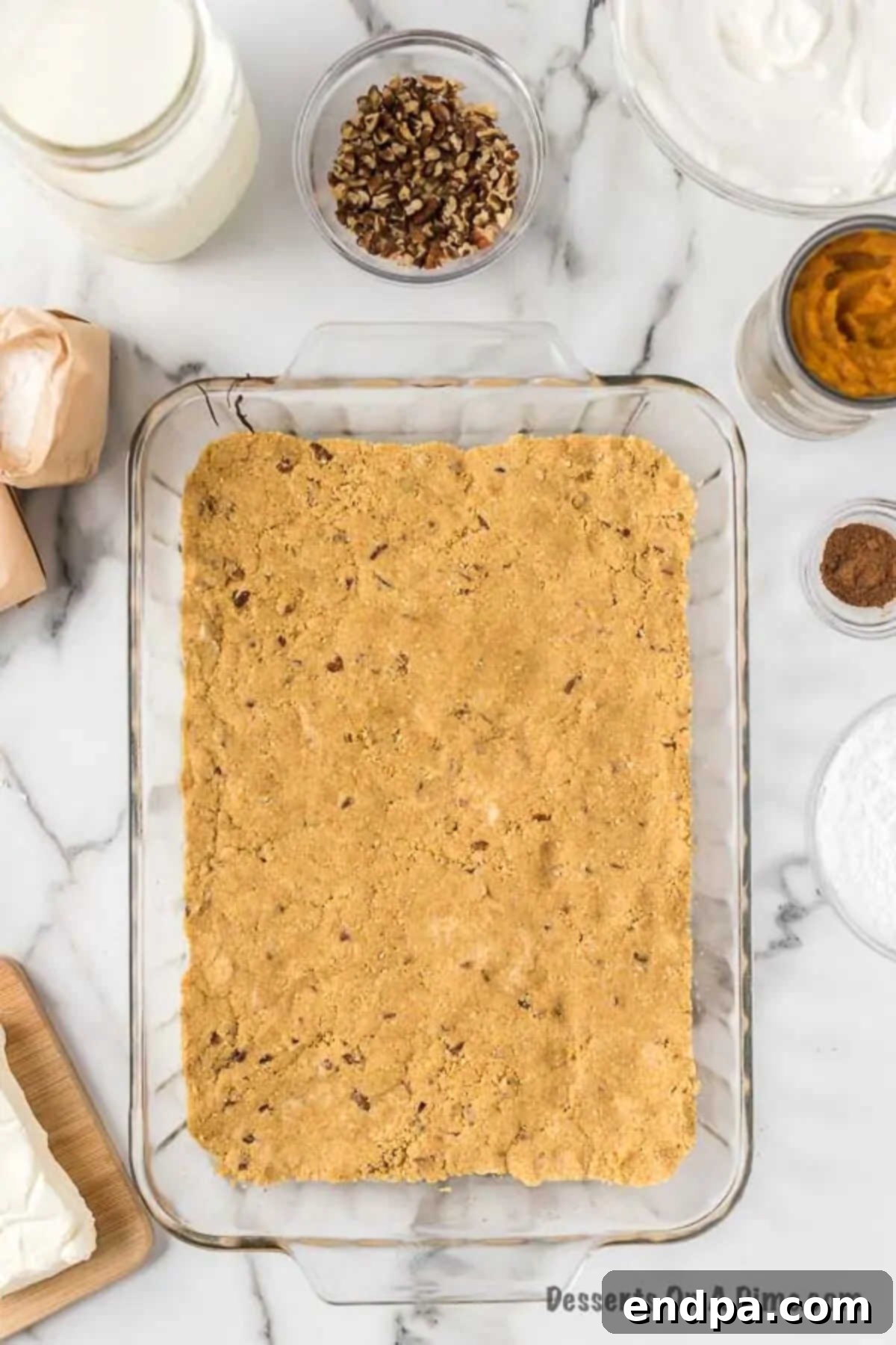 Pressing the graham cracker and pecan crust mixture evenly into a 9x13 inch baking dish.