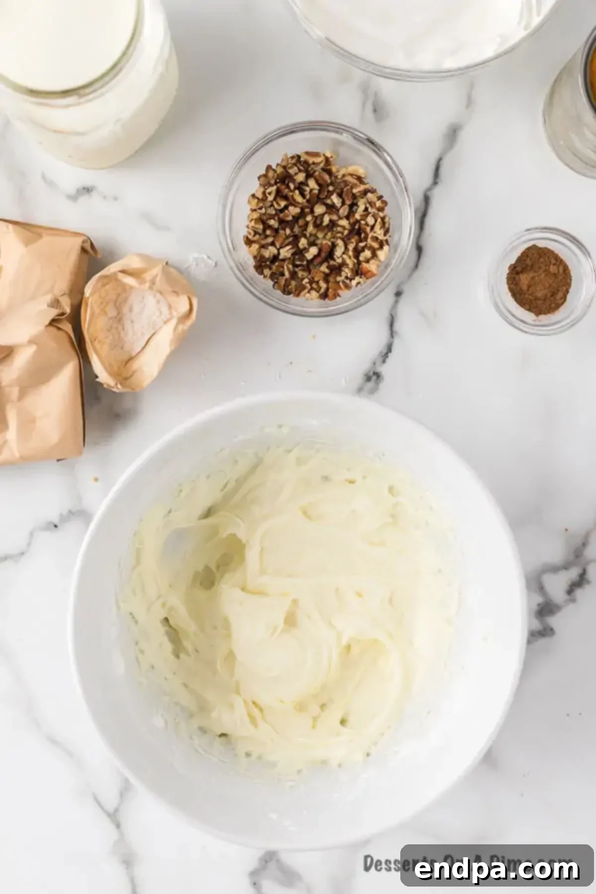 Blending softened cream cheese and powdered sugar in a bowl using a hand mixer until smooth.
