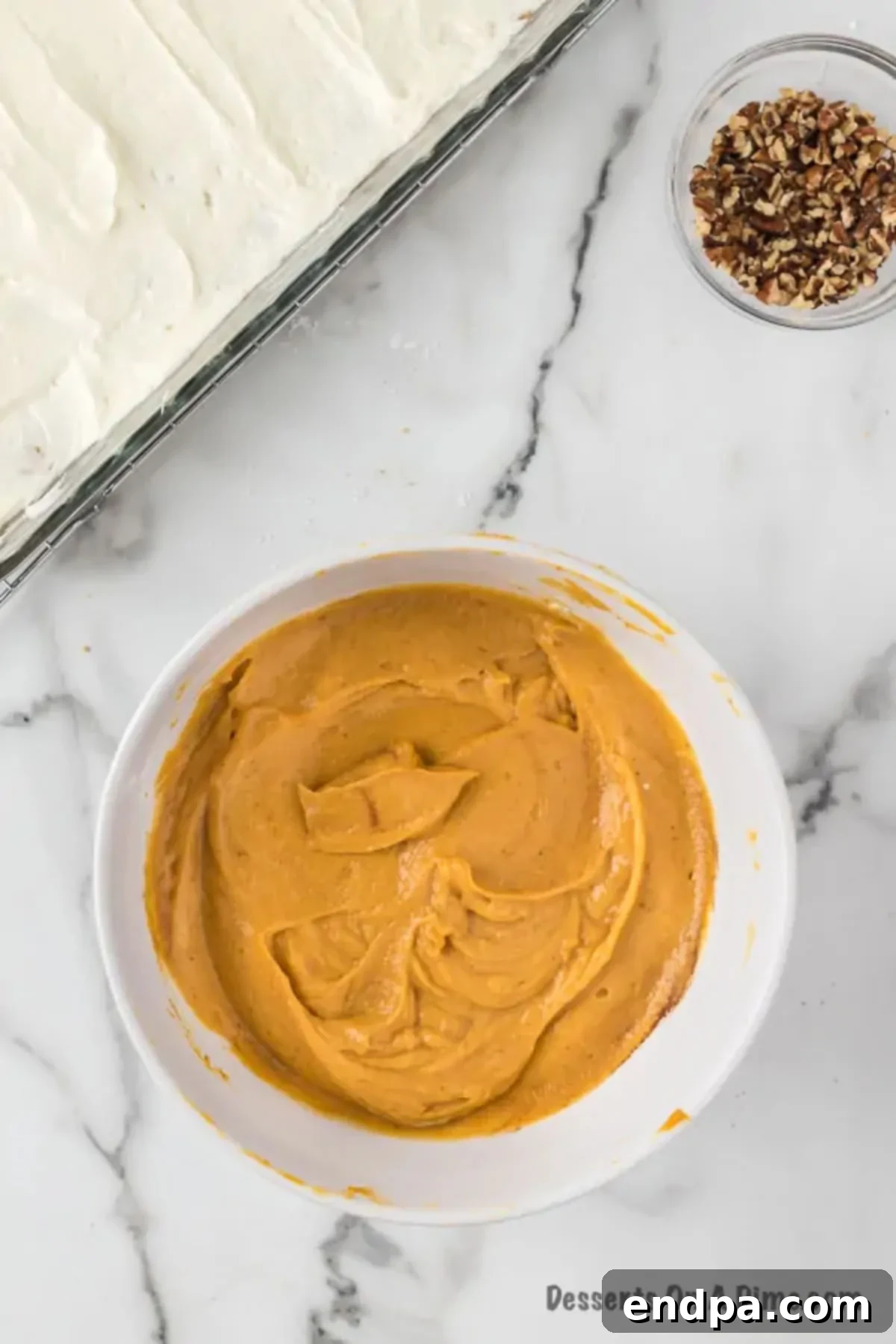 Mixing milk, instant pudding mix, canned pumpkin puree, pumpkin spice, and a portion of whipped topping in a large bowl to form the pumpkin layer.