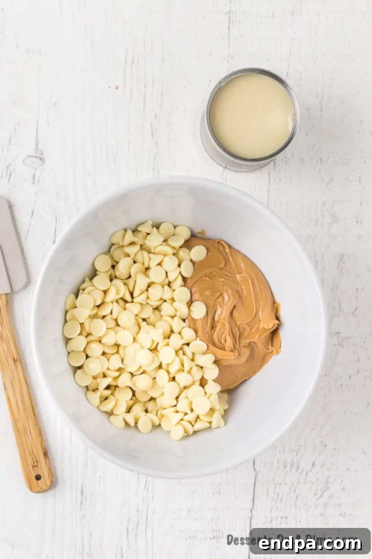Bowl with white chocolate chips and creamy peanut butter ready for melting.