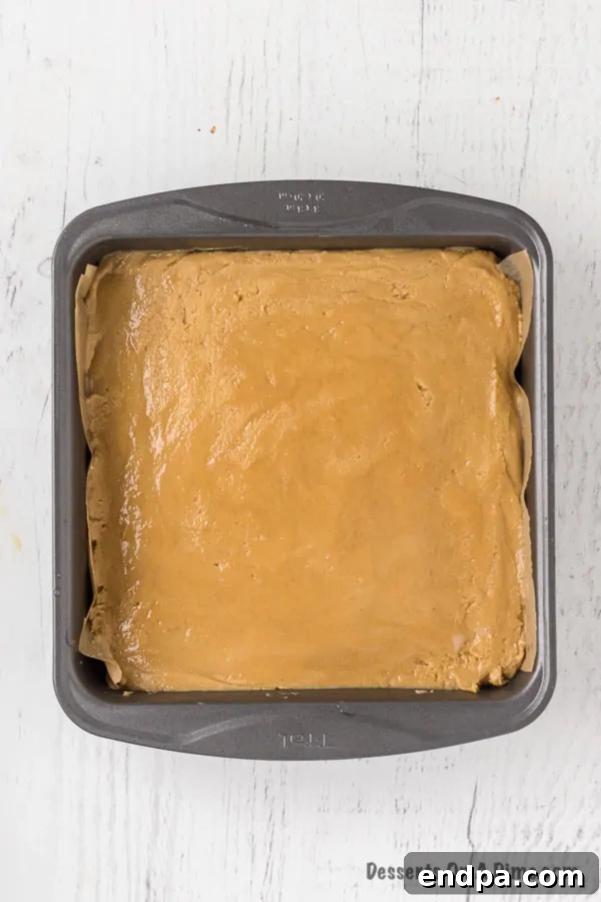 The smooth peanut butter fudge mixture spread evenly in the prepared baking dish.